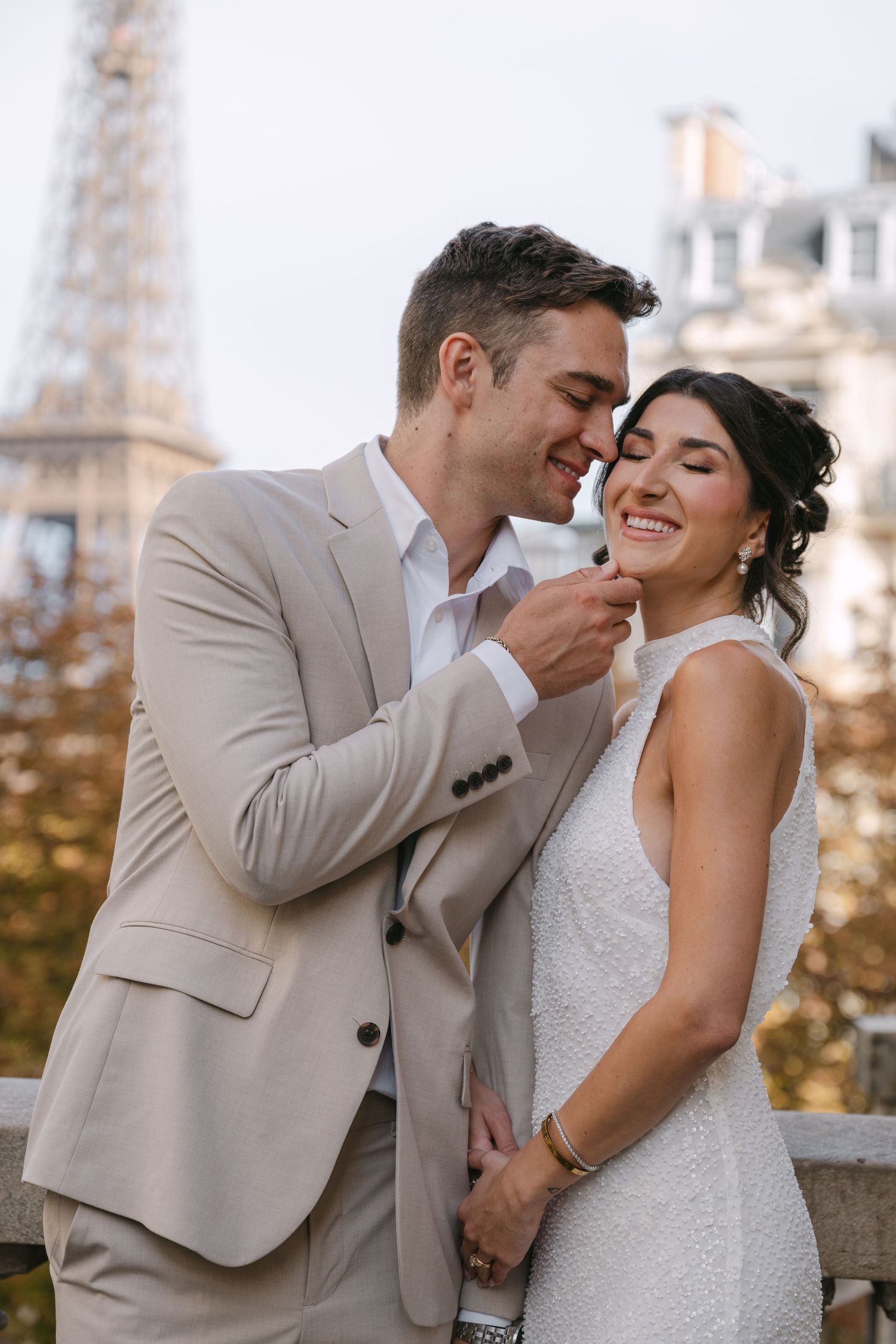 A couple shares joyful laughter during their wedding photoshoot in Paris.