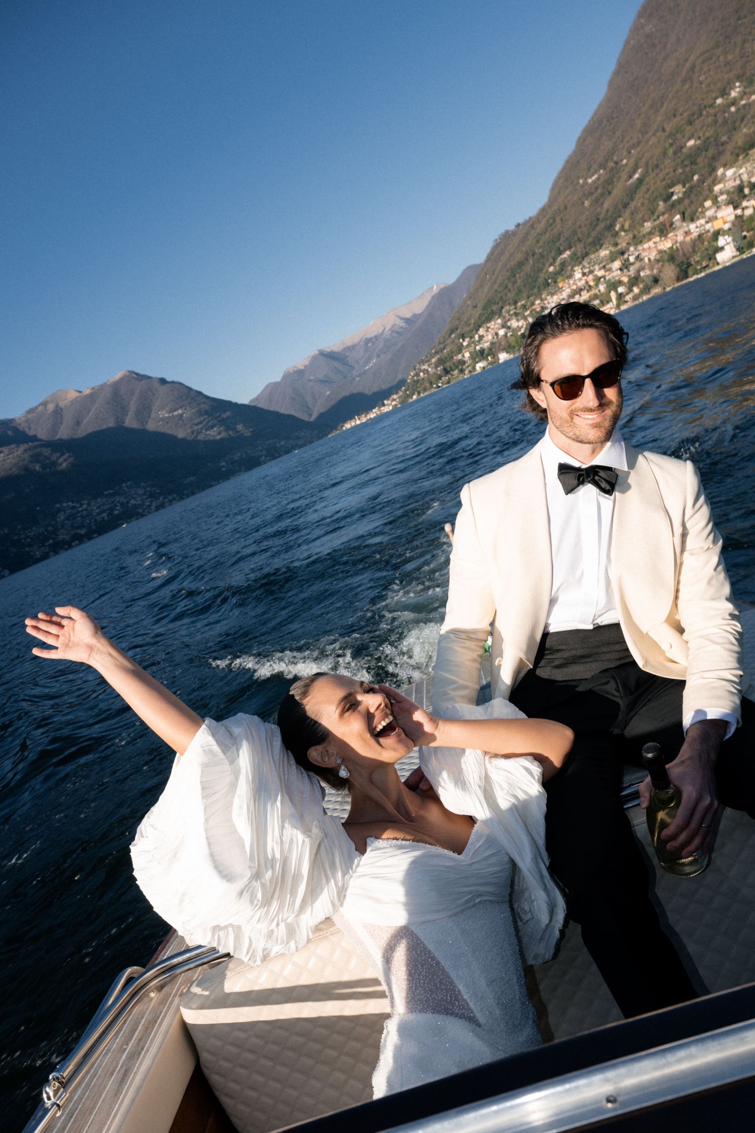 A couple inwedding attire enjoying a boat ride on lake como , boat photoshoot. Lake Como Elopement Wedding Photographer