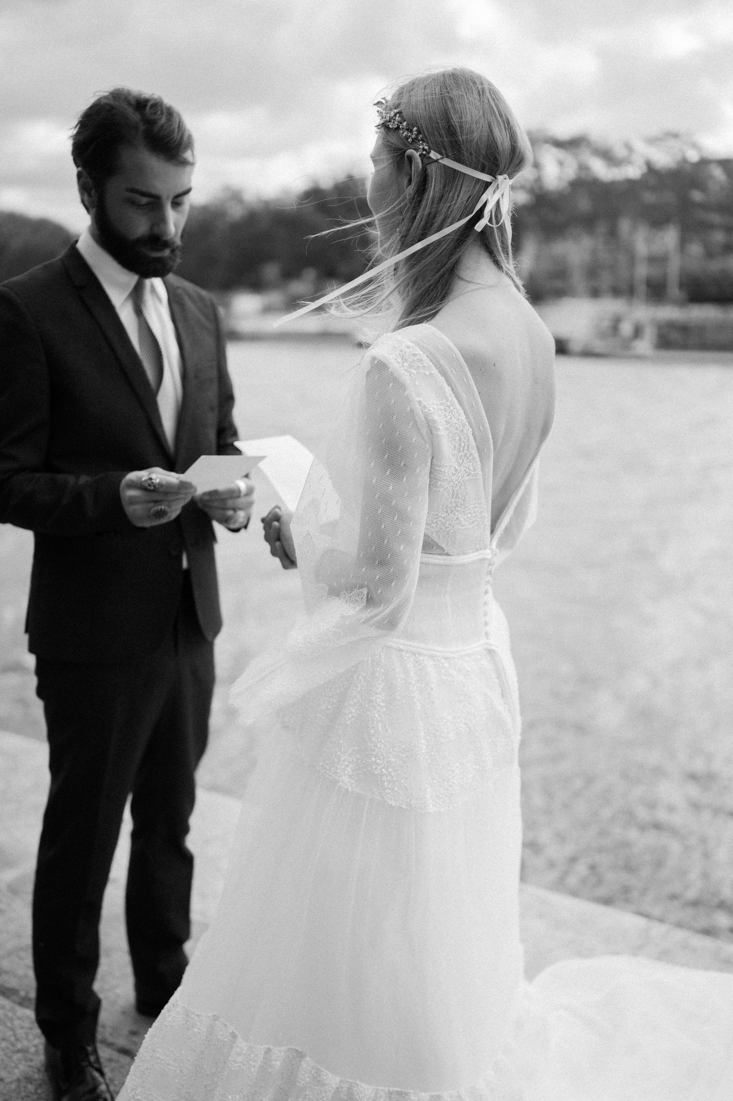 A couple shares a private moment during their wedding ceremony by the water.