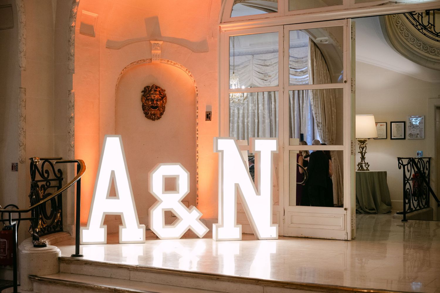 Illuminated marquee letter signs spelling A&N displayed at elegant wedding venue entrance with warm ambient lighting.