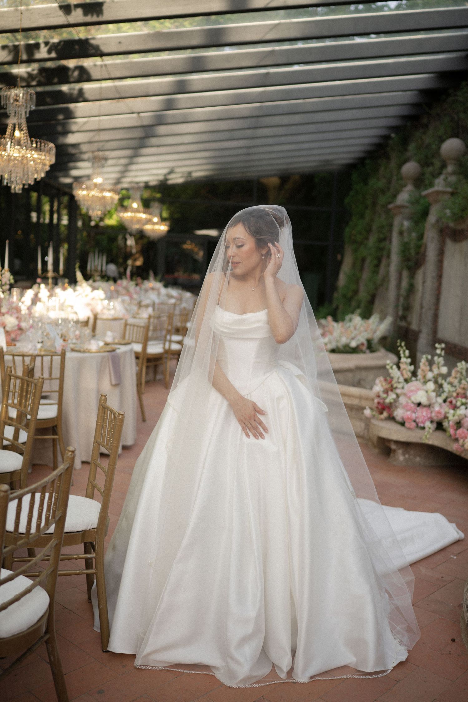 Bride in a white ballgown at Casa dos Penedos and veil stands in a decorated wedding venue in Sintra, Portugal