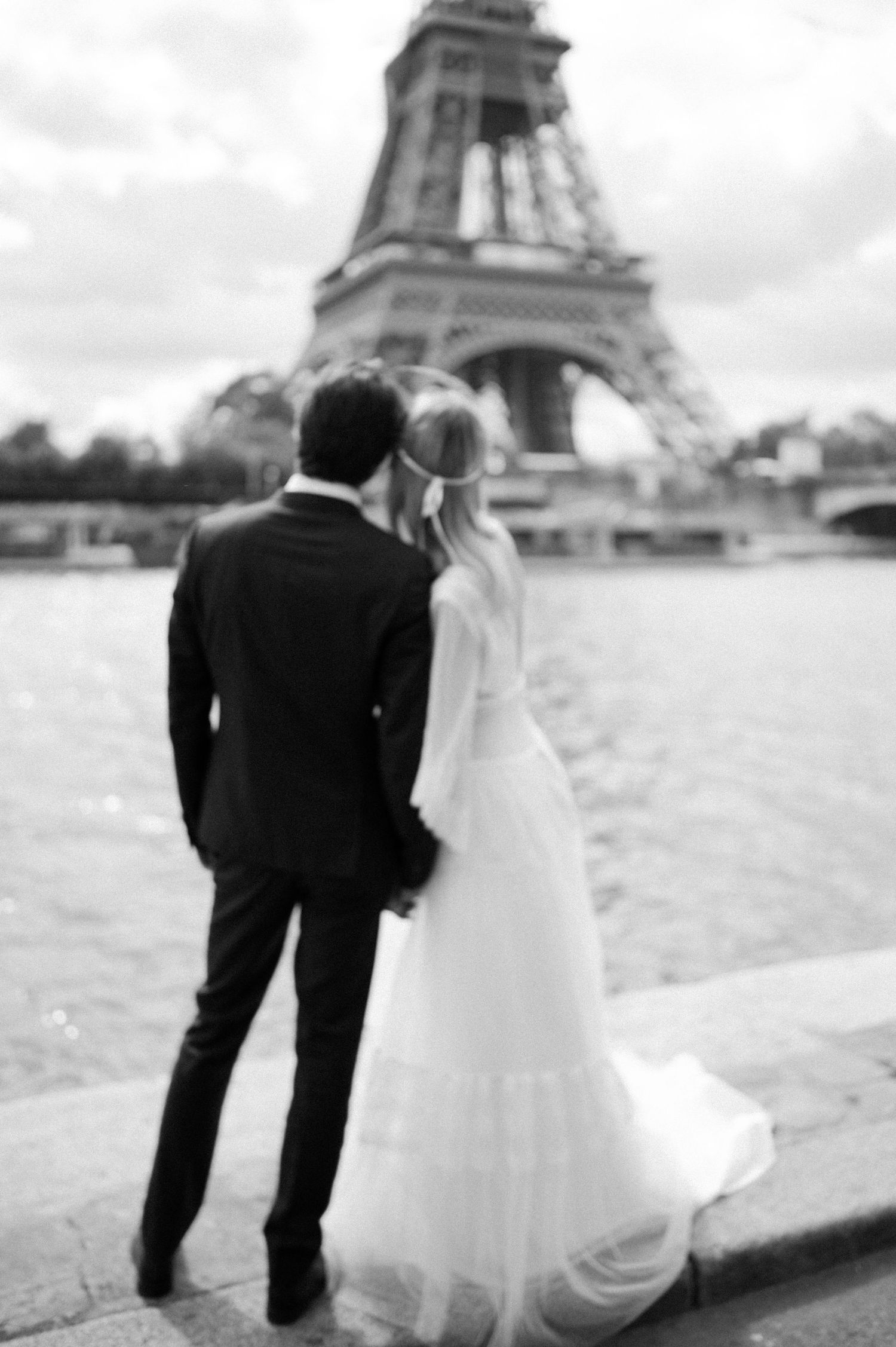 Newlyweds admire the Eiffel Tower together after their Paris wedding ceremony.