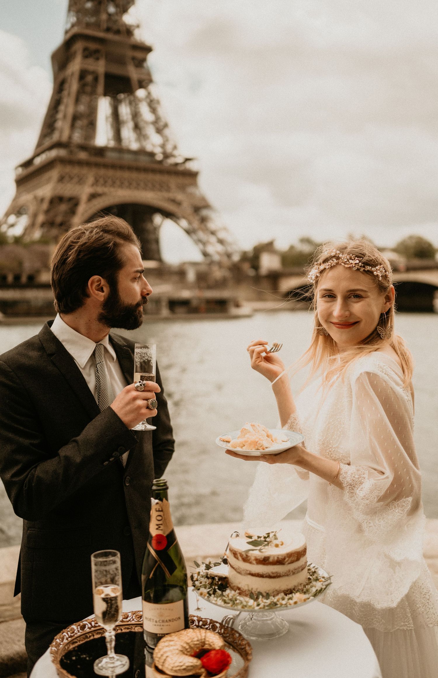 A romantic wedding celebration with champagne and cake near the Eiffel Tower.
