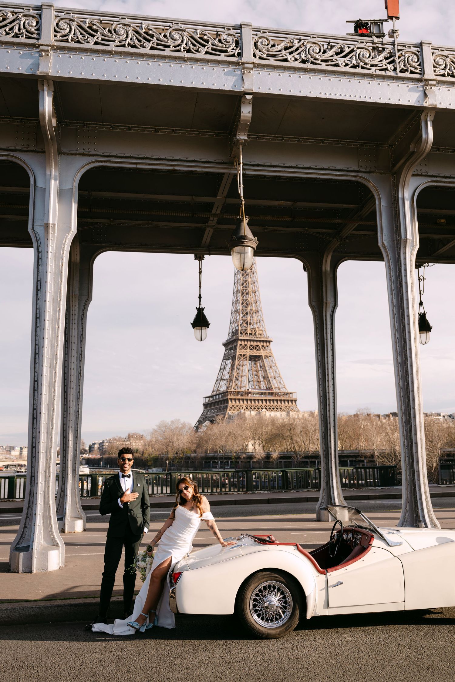 Panoramic view of the Eiffel Tower through Bir-Hakeim bridge's iconic metal arches in Paris, France.