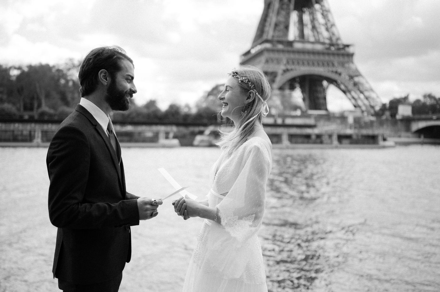 A joyful wedding couple sharing vows in front of the iconic Eiffel Tower.