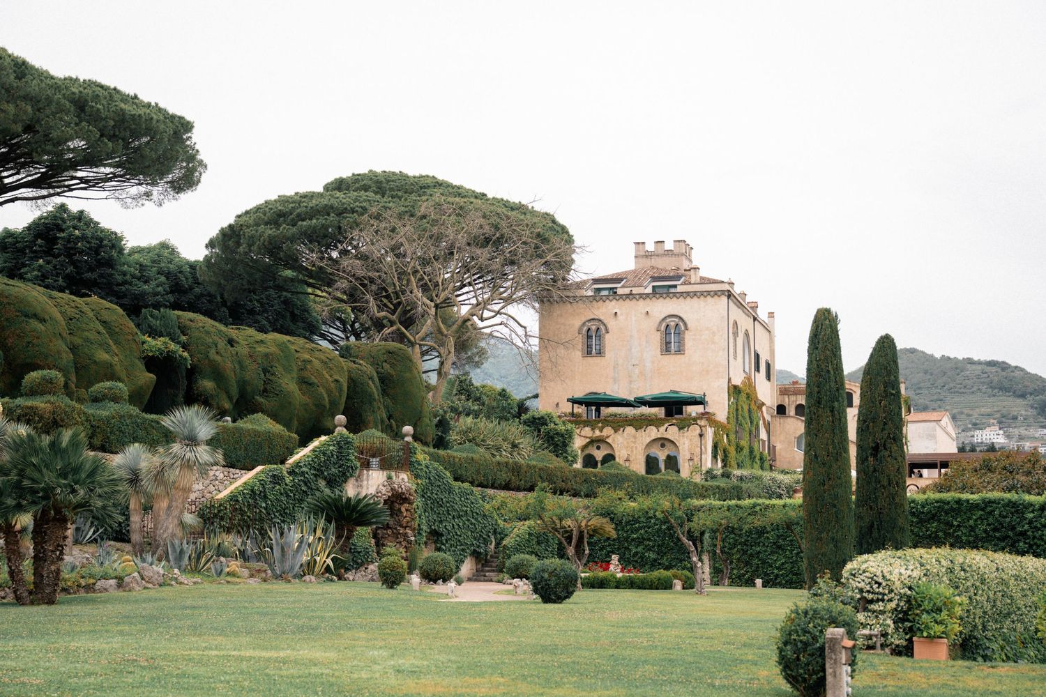 Stunning Italian villa wedding venue with manicured gardens, cypress trees, and terracotta architecture.