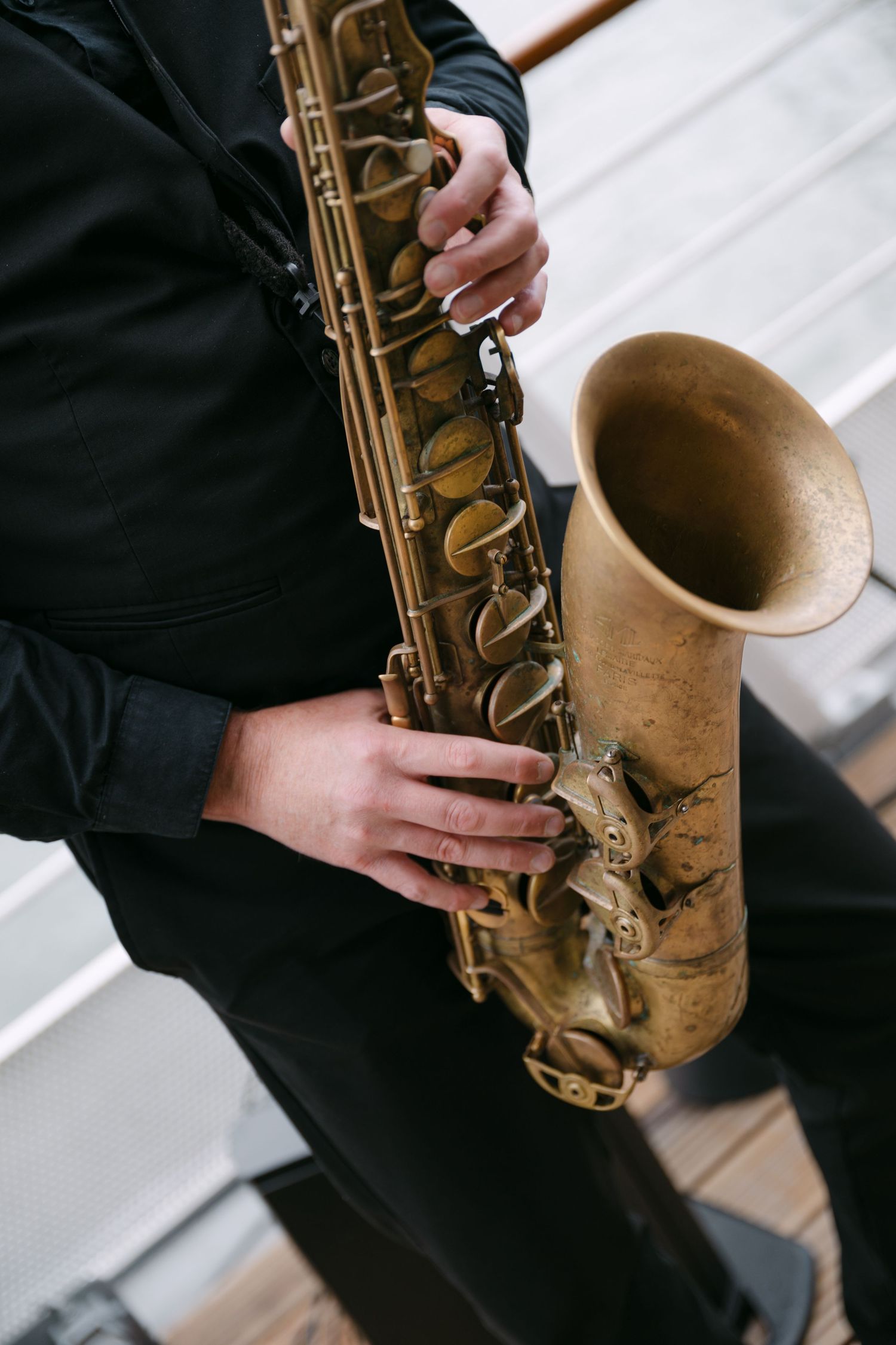 Close-up of a musician\u2019s hands playing a vintage brass saxophone at a wedding event.