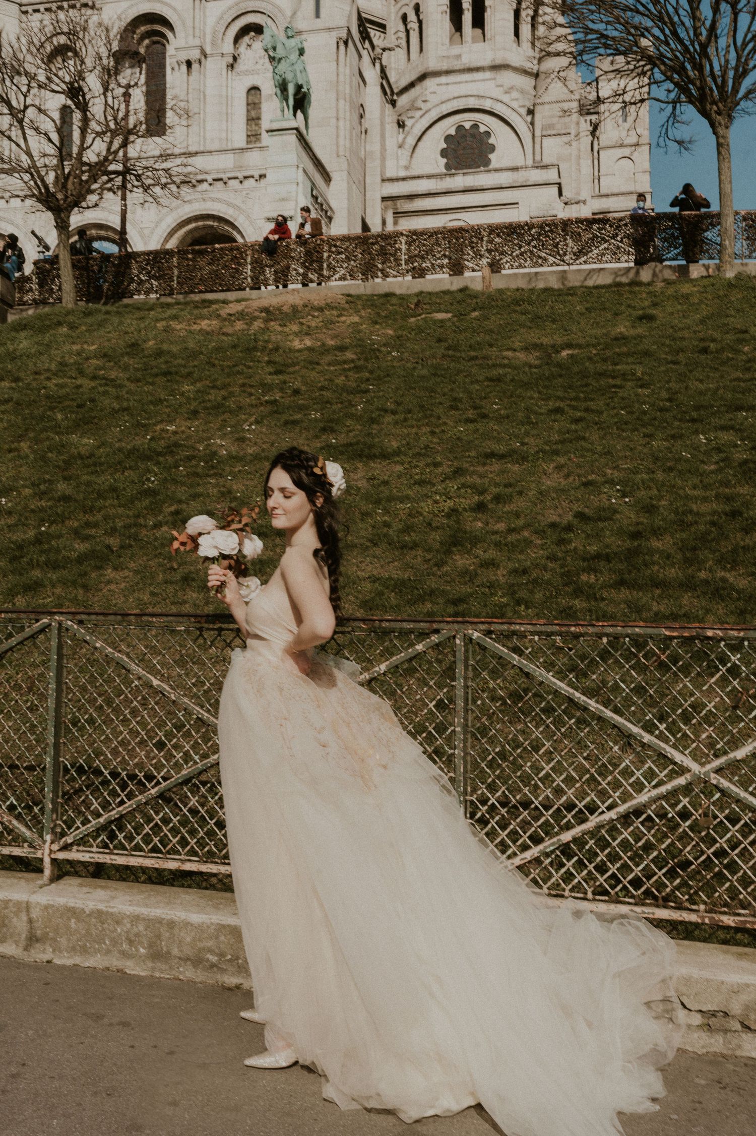 Ethereal bridal portrait with cathedral backdrop and flowing dress in warm sunlight.