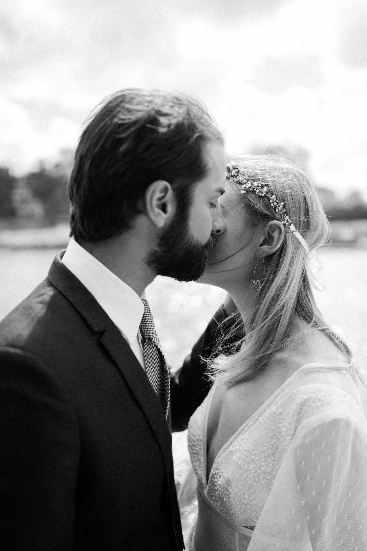 Black and white romantic wedding photo of couple sharing tender moment outdoors.