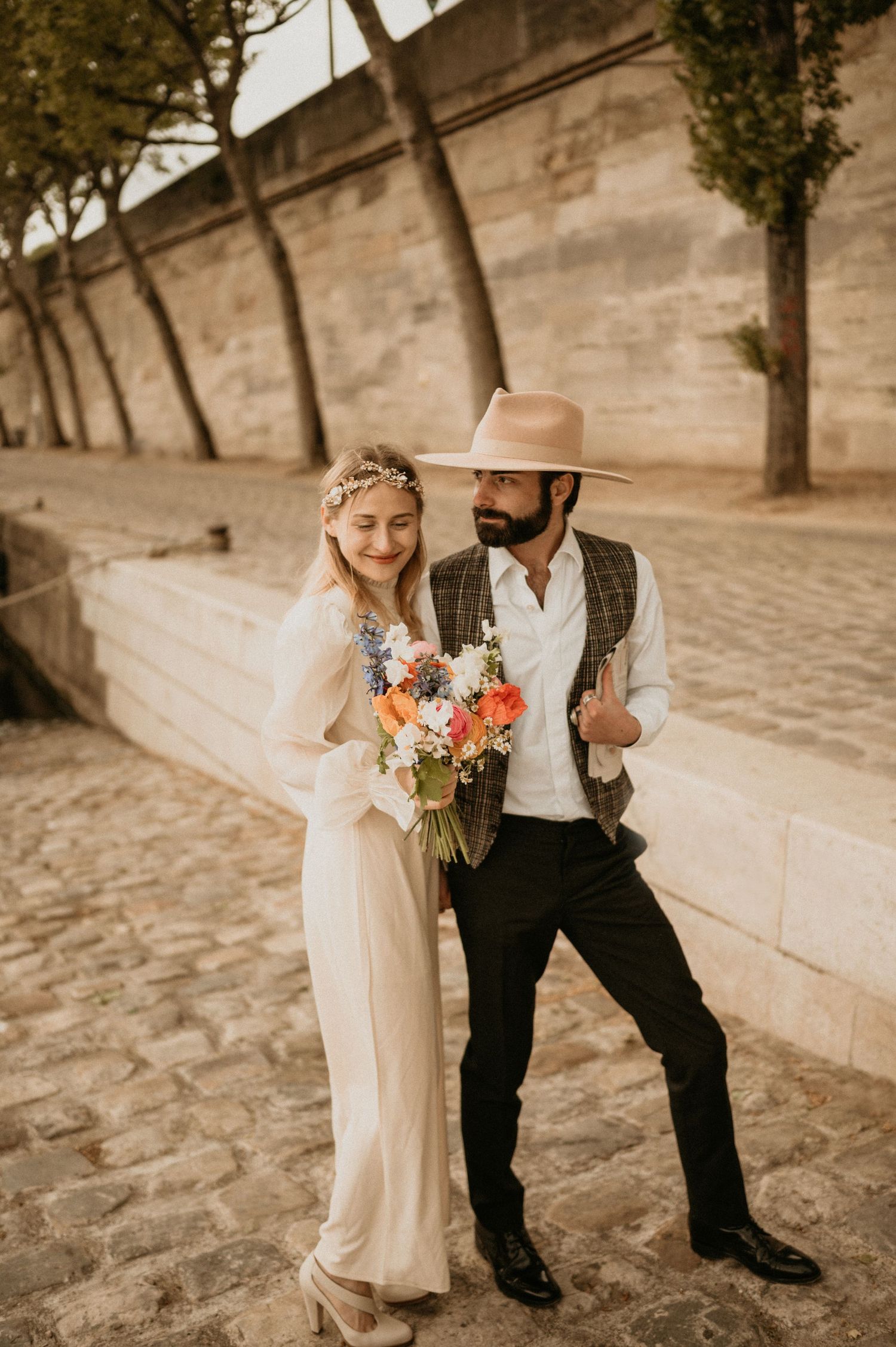 A romantic portrait of newlyweds with vintage styling on a cobblestone street in Paris.