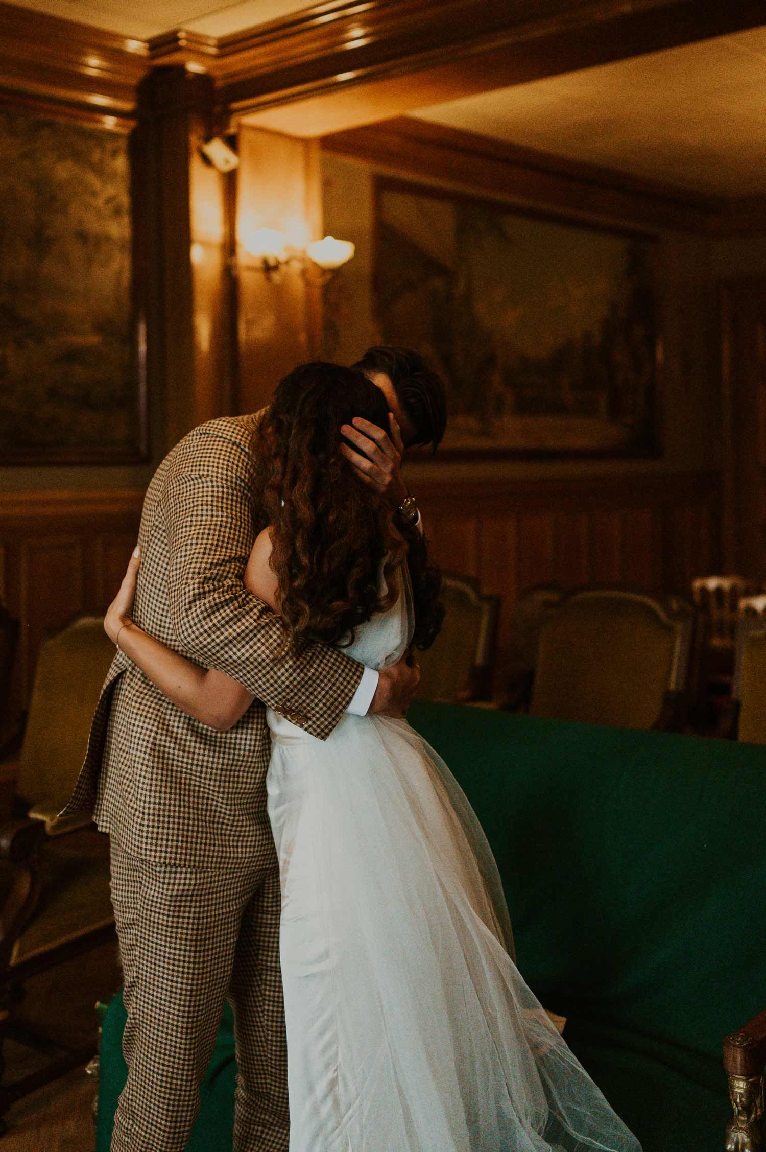A tender moment captured between newlyweds in a warmly lit vintage room.