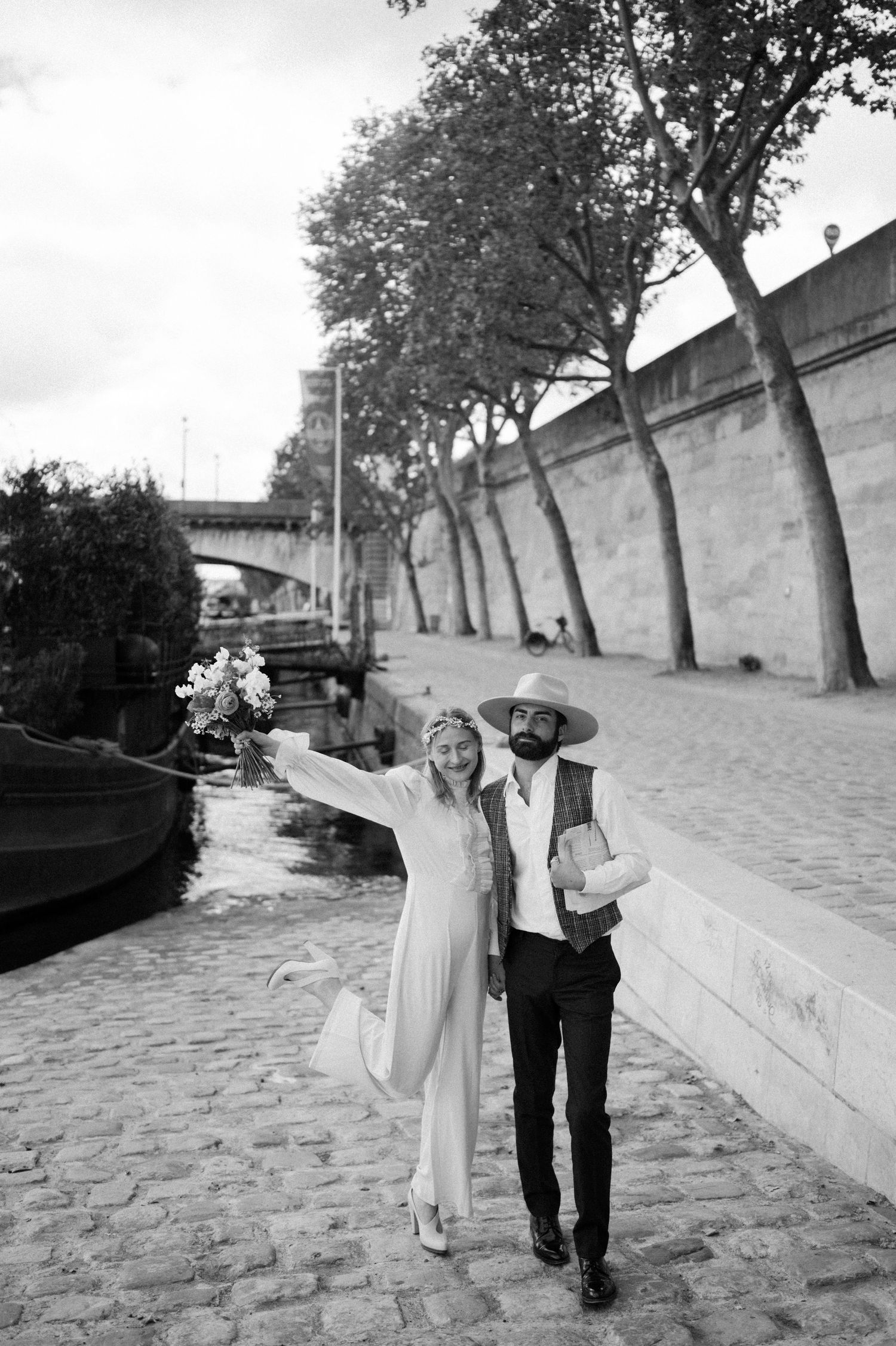 A black and white portrait of a couple strolling along the Seine River in Paris.