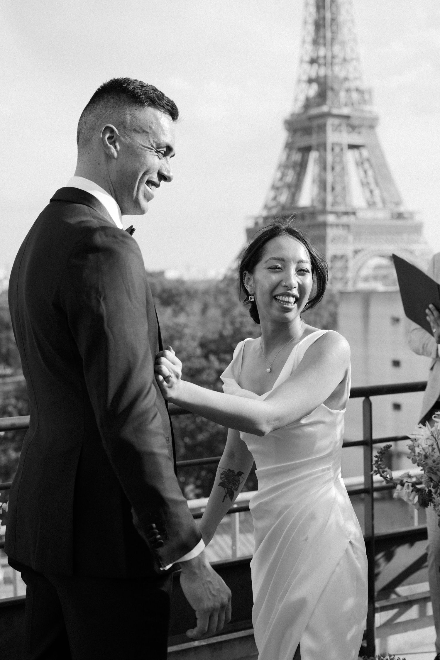 A couple shares joyful moments in a series of black and white photos with the Eiffel Tower visible in the background.