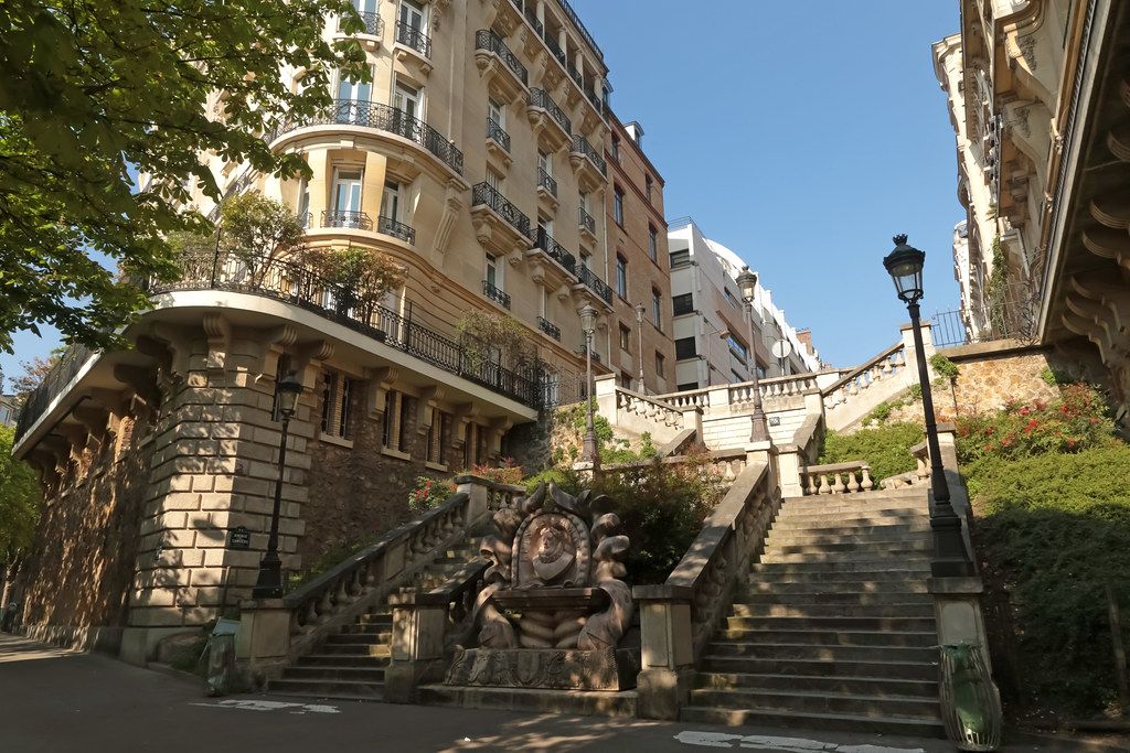 Charming Parisian street with stone steps and classic Haussmanian architecture.