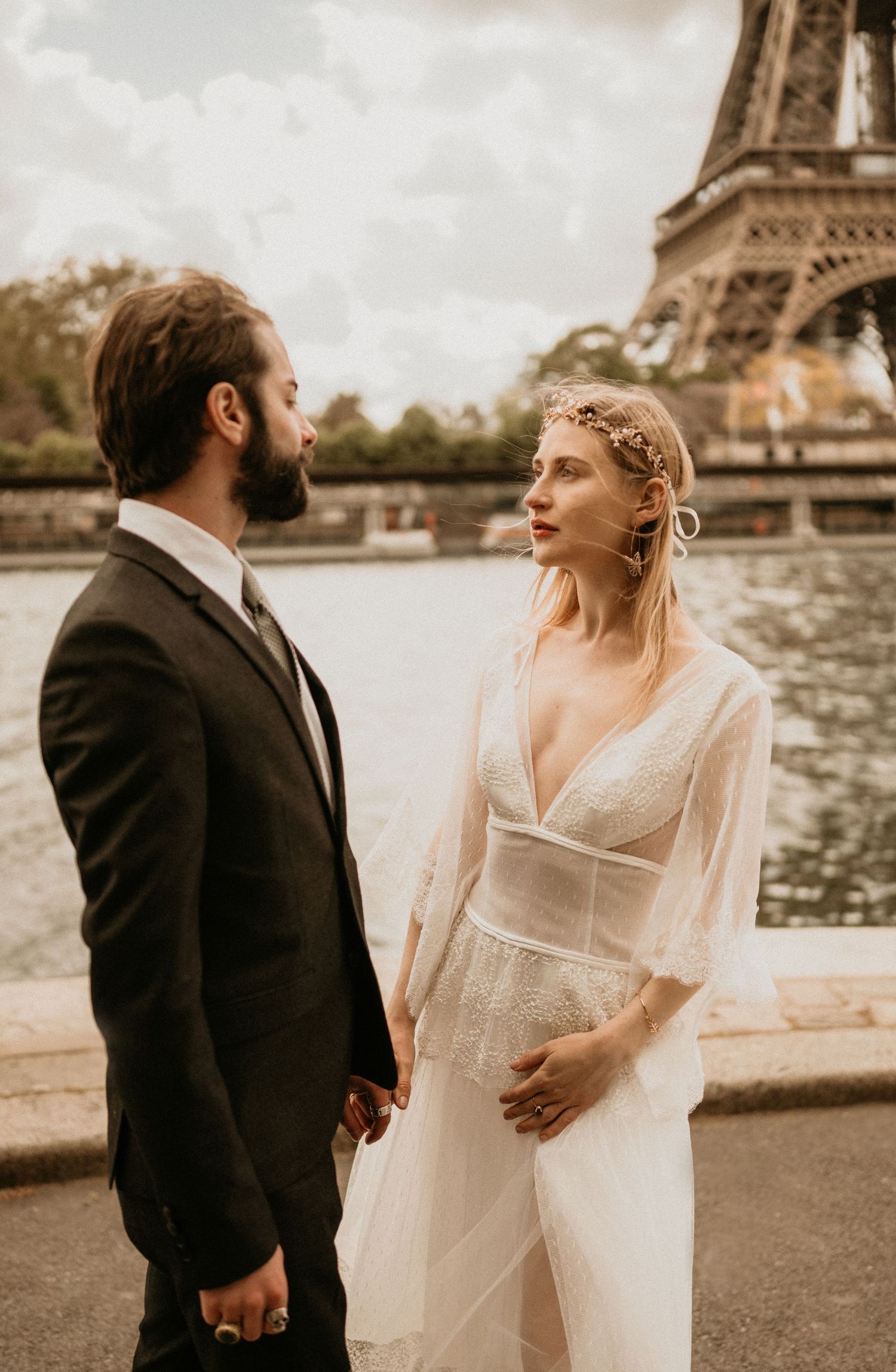 Intimate wedding moment captured in warm tones with the iconic Eiffel Tower in the background.