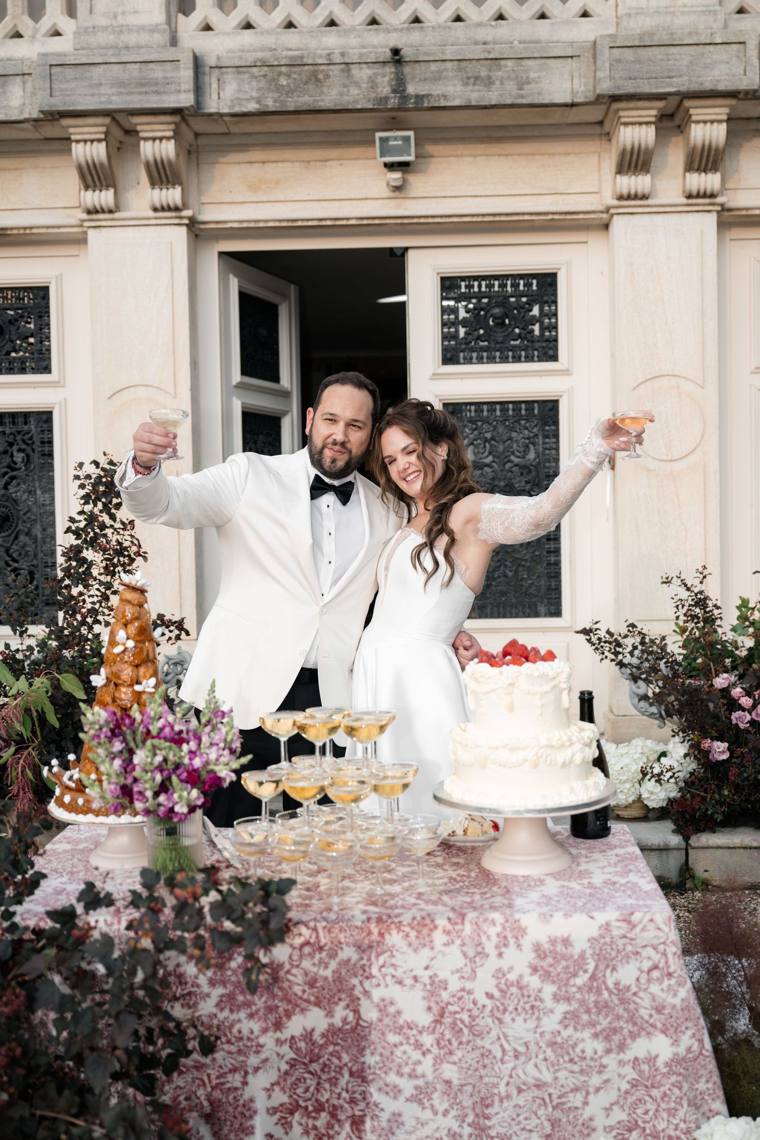 Wedding cake cutting celebration at an elegant venue with white tablecloth and champagne glasses.