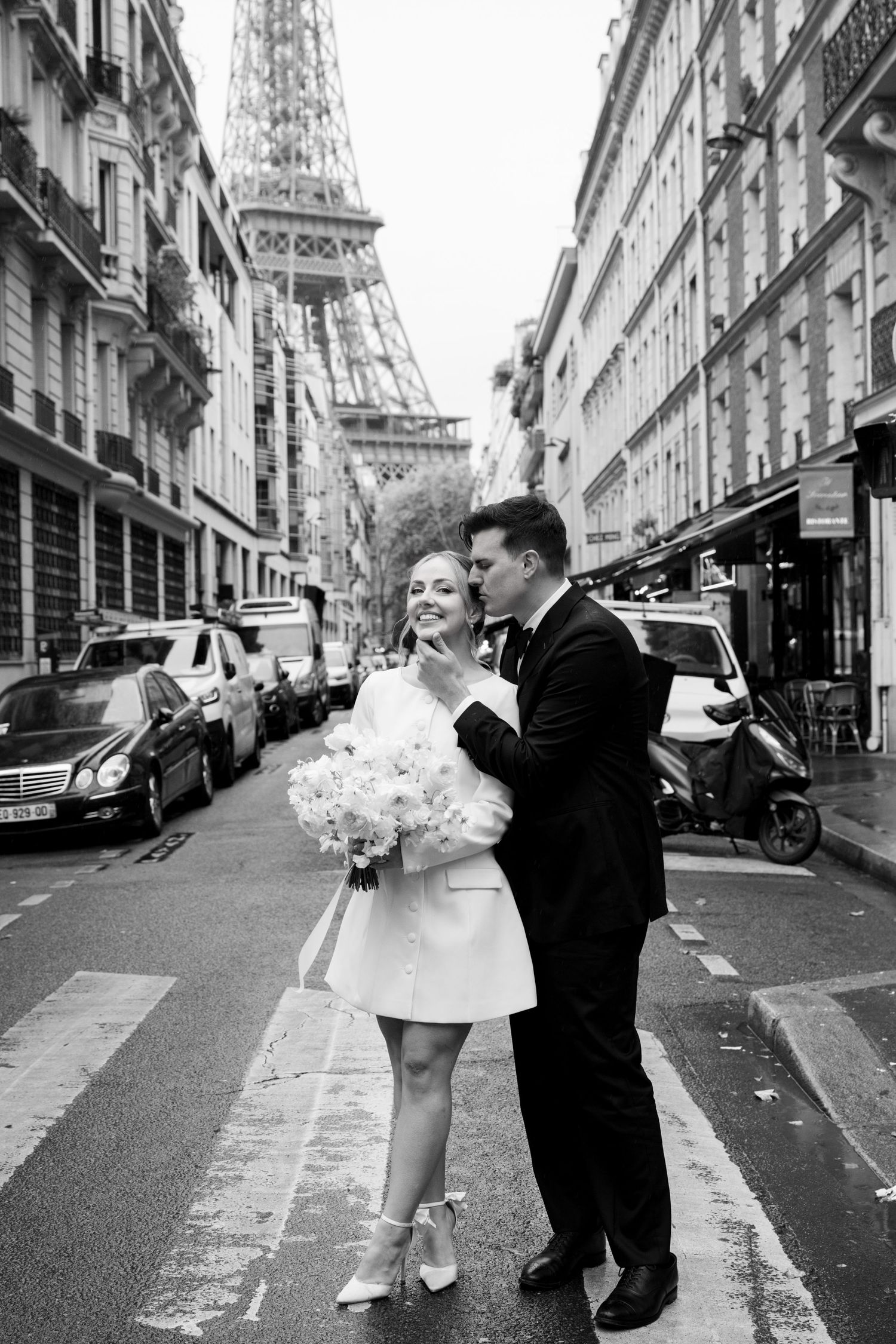 A romantic black and white photo series of a couple dancing in the streets of Paris with the Eiffel Tower in view.