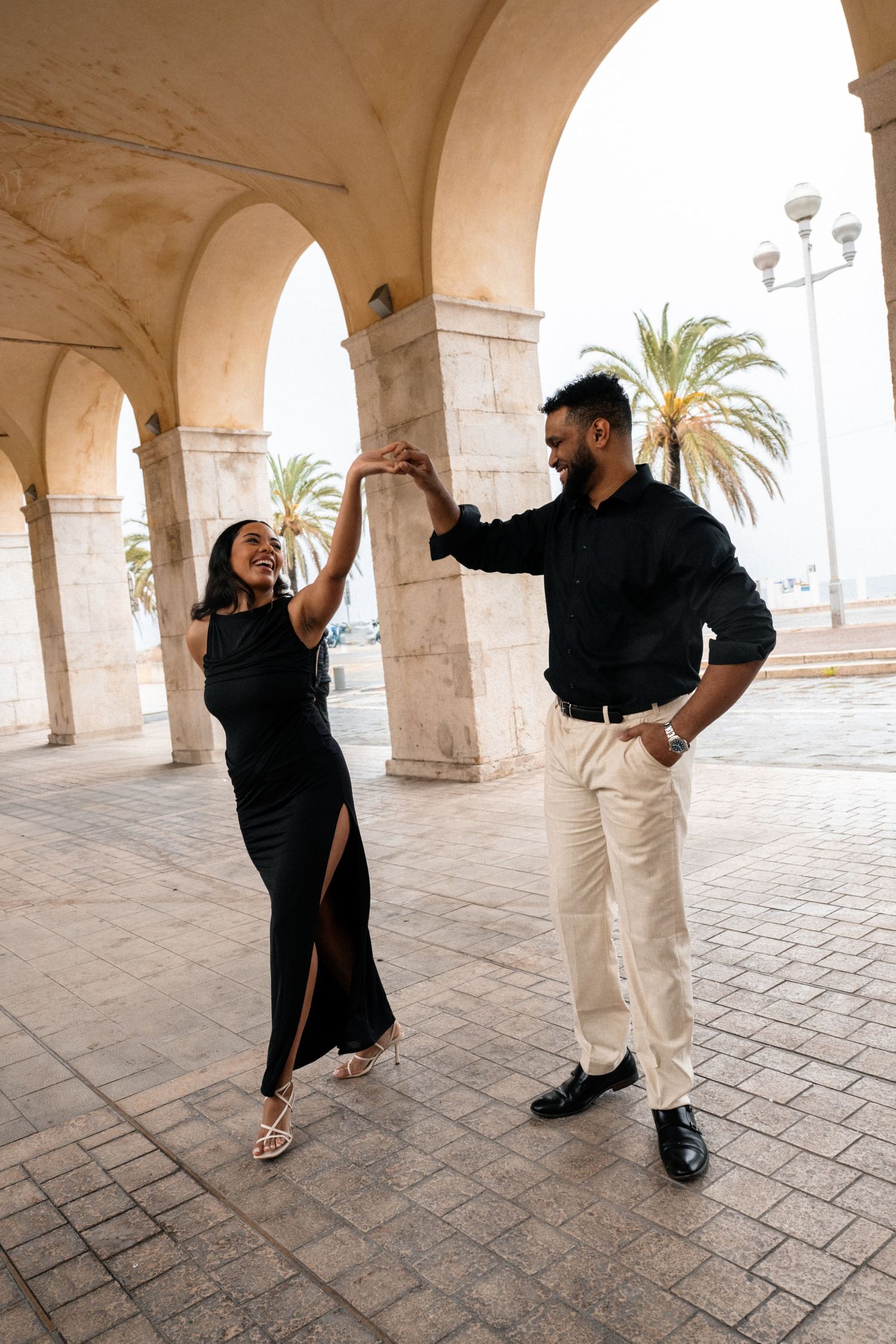 Two hands touch tenderly against a blurry cityscape backdrop, with one person wearing an elegant wristwatch.