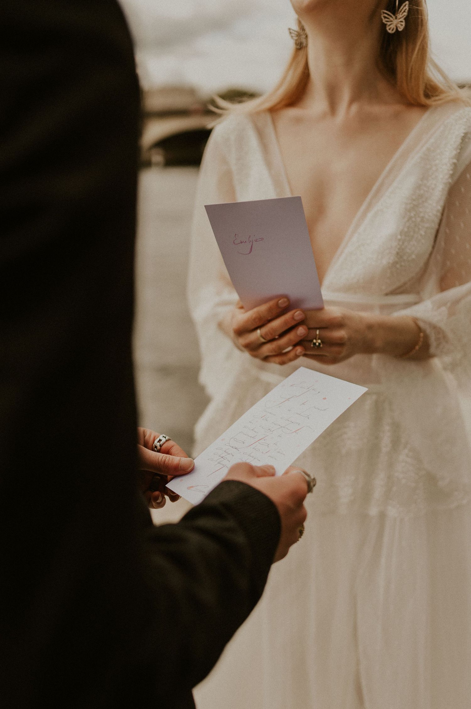 Close-up of couple exchanging written vows during intimate wedding ceremony.