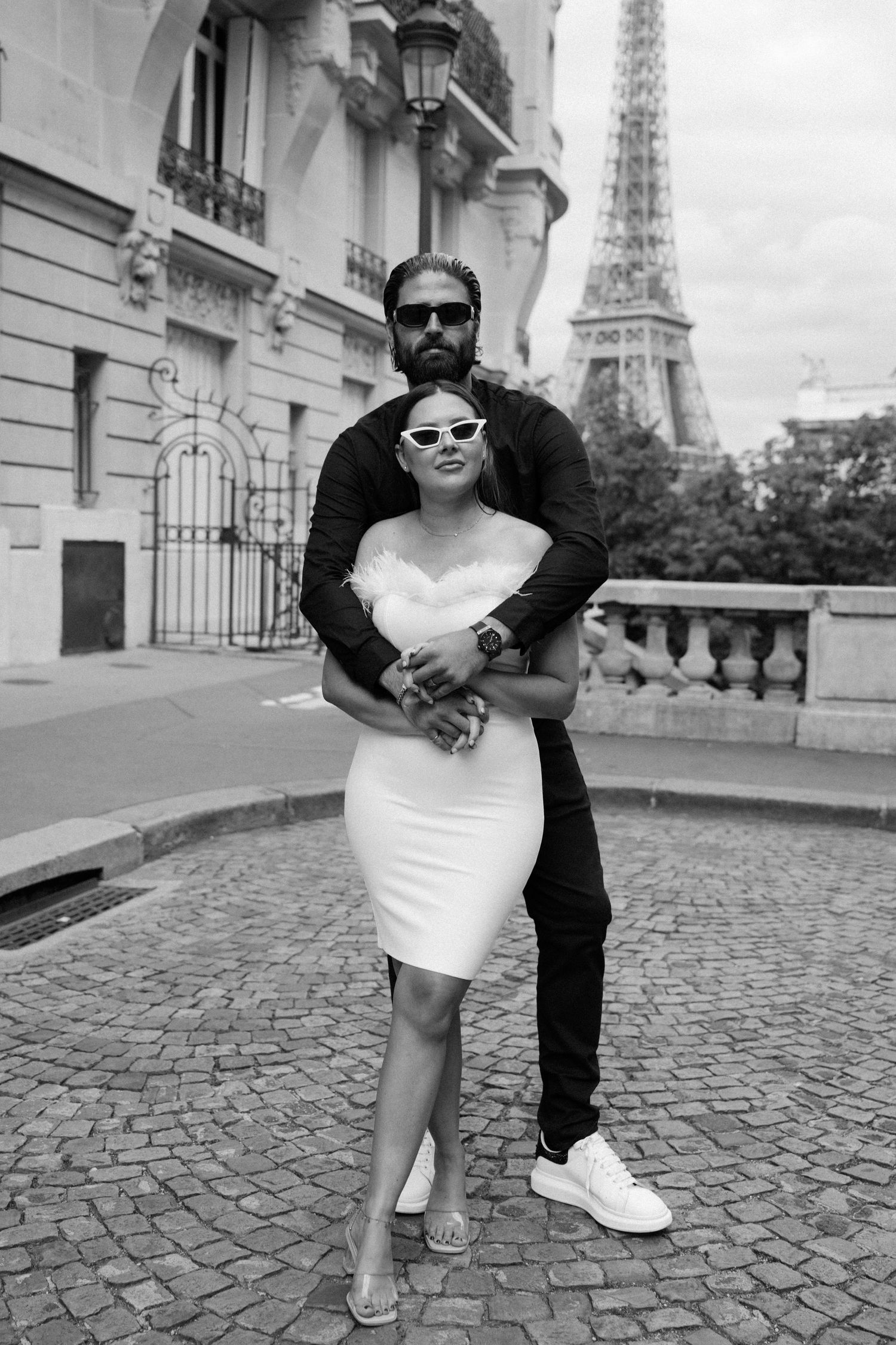 Black and white wedding portrait with the iconic Eiffel Tower and Parisian architecture in the background.