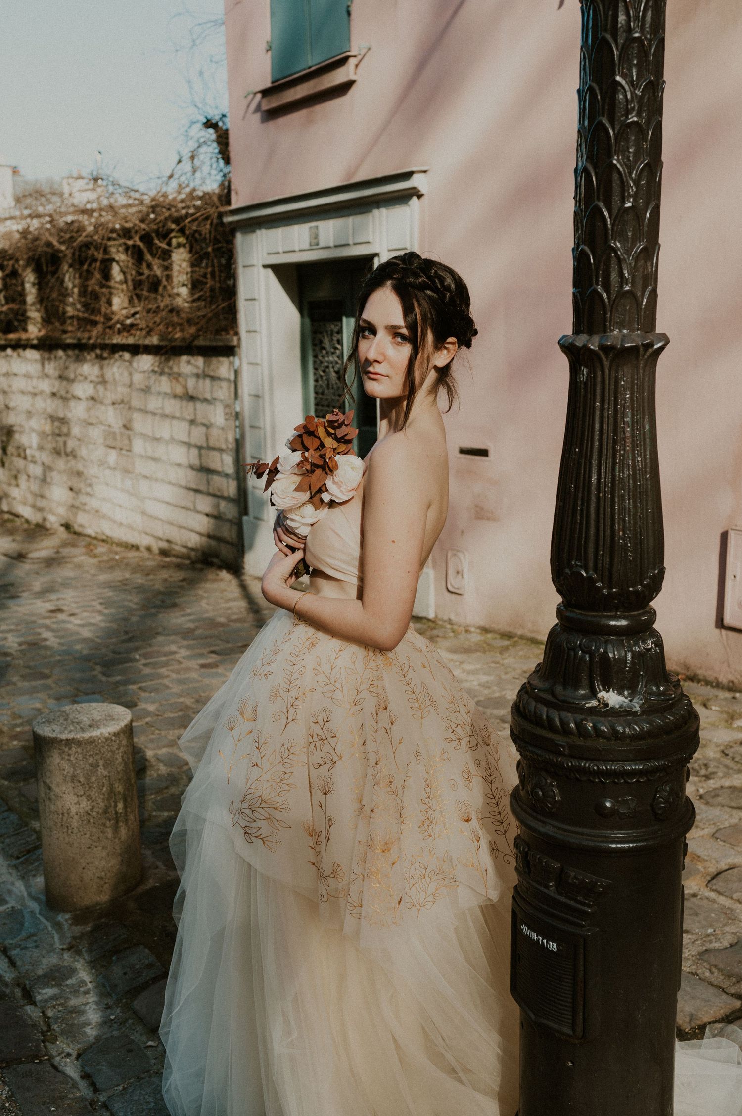 Romantic bridal portrait next to vintage lamppost on cobblestone street.