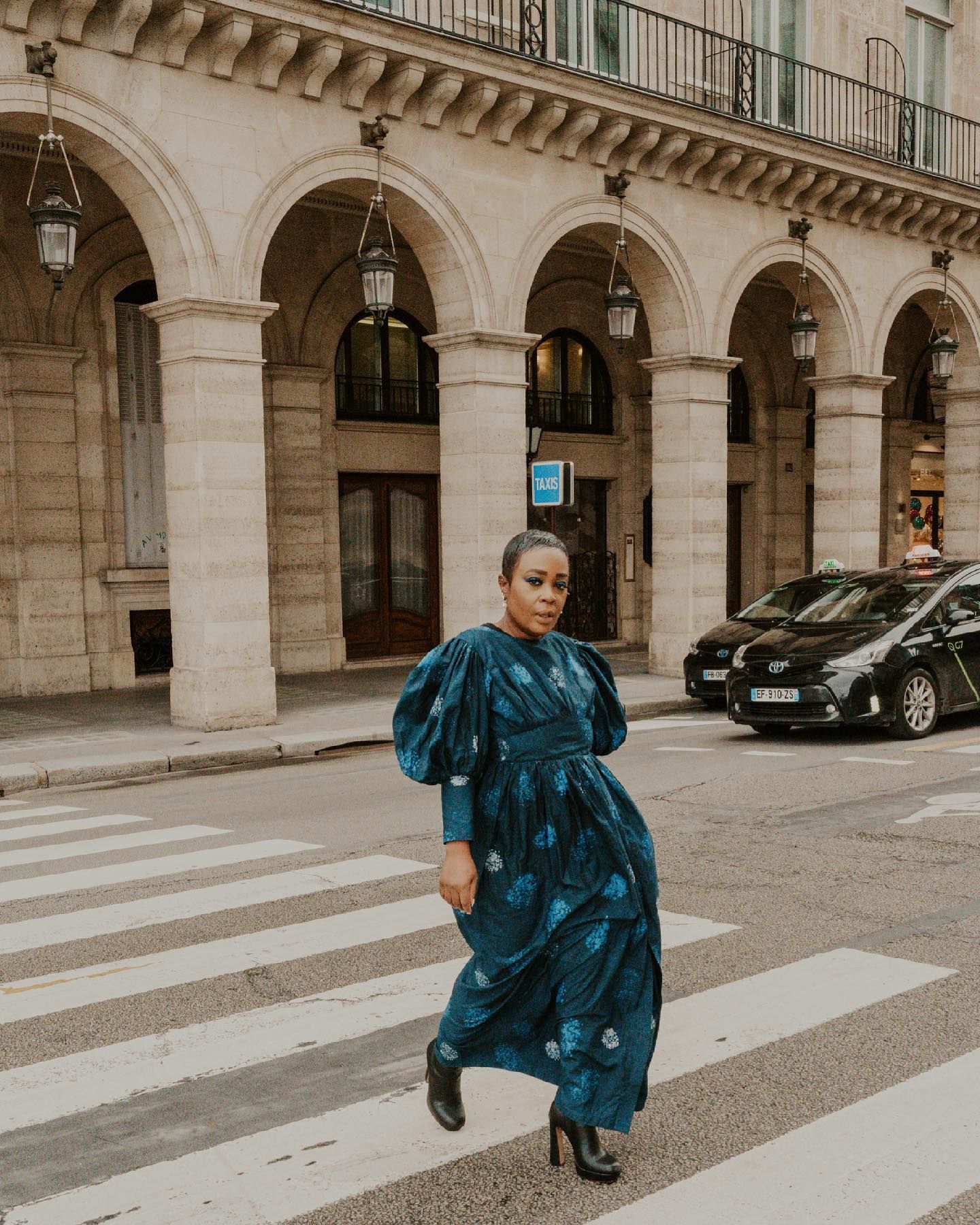Classic Parisian architecture with stone arches and elegant street view.