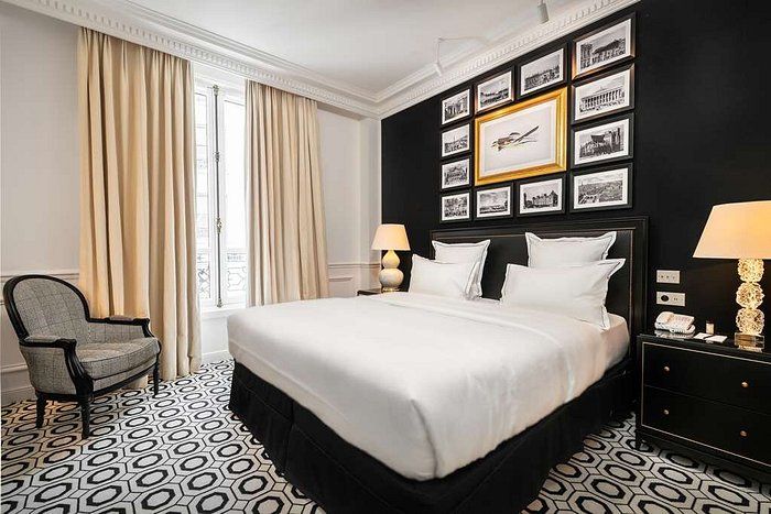 Luxurious Parisian hotel room with dark walls, crystal chandelier and elegant French windows.