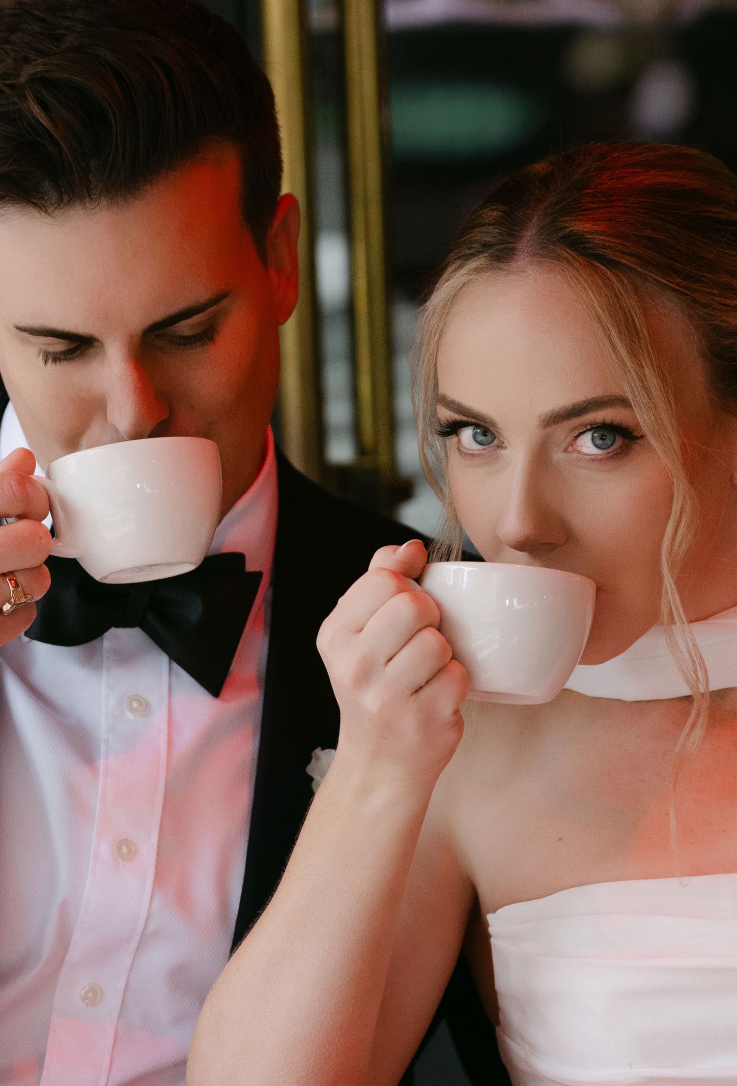 Close-up sequence of a bride and groom sipping coffee together at a cafe.