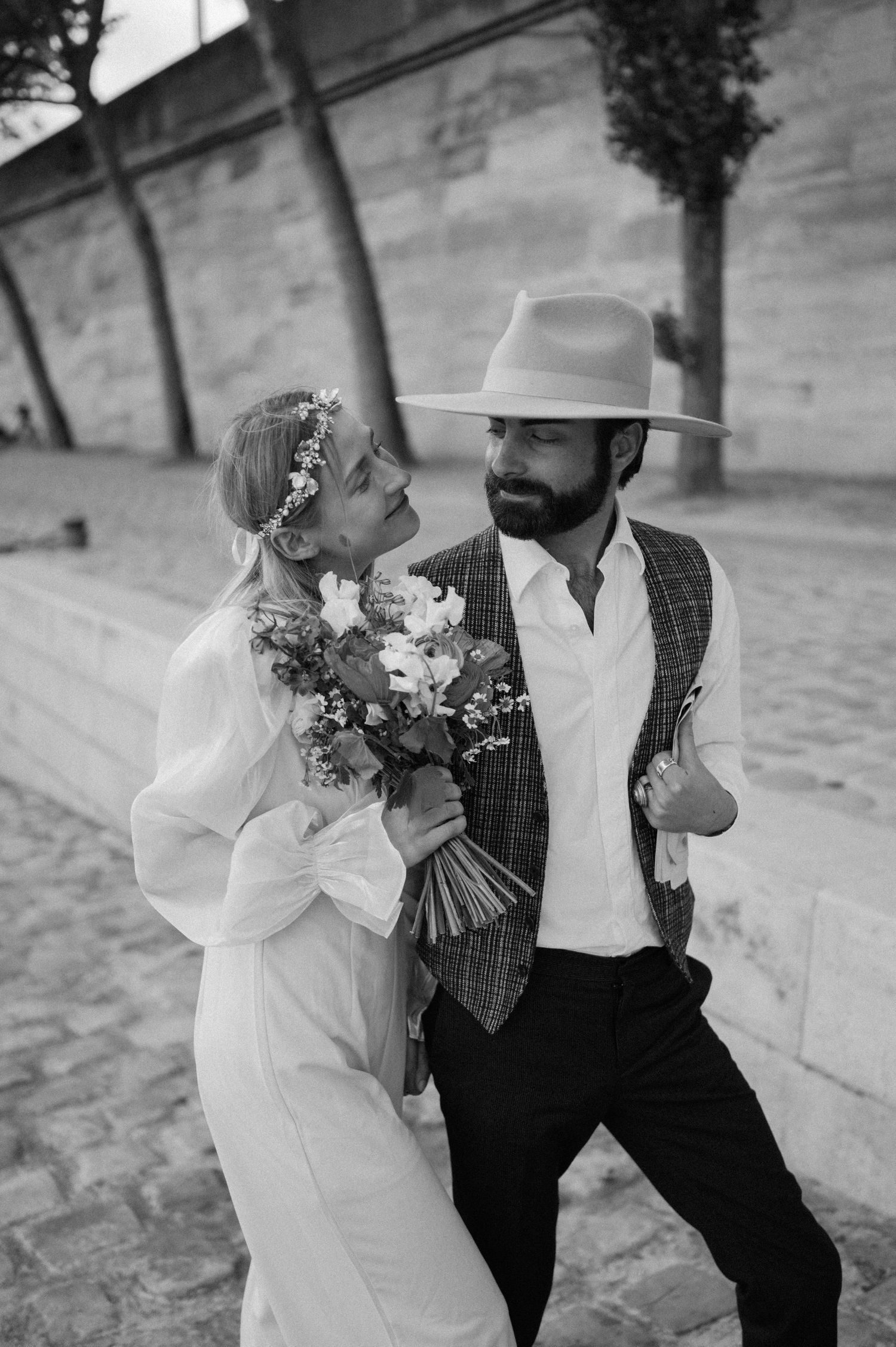 A black and white portrait of a couple laughing together during their Parisian wedding shoot.