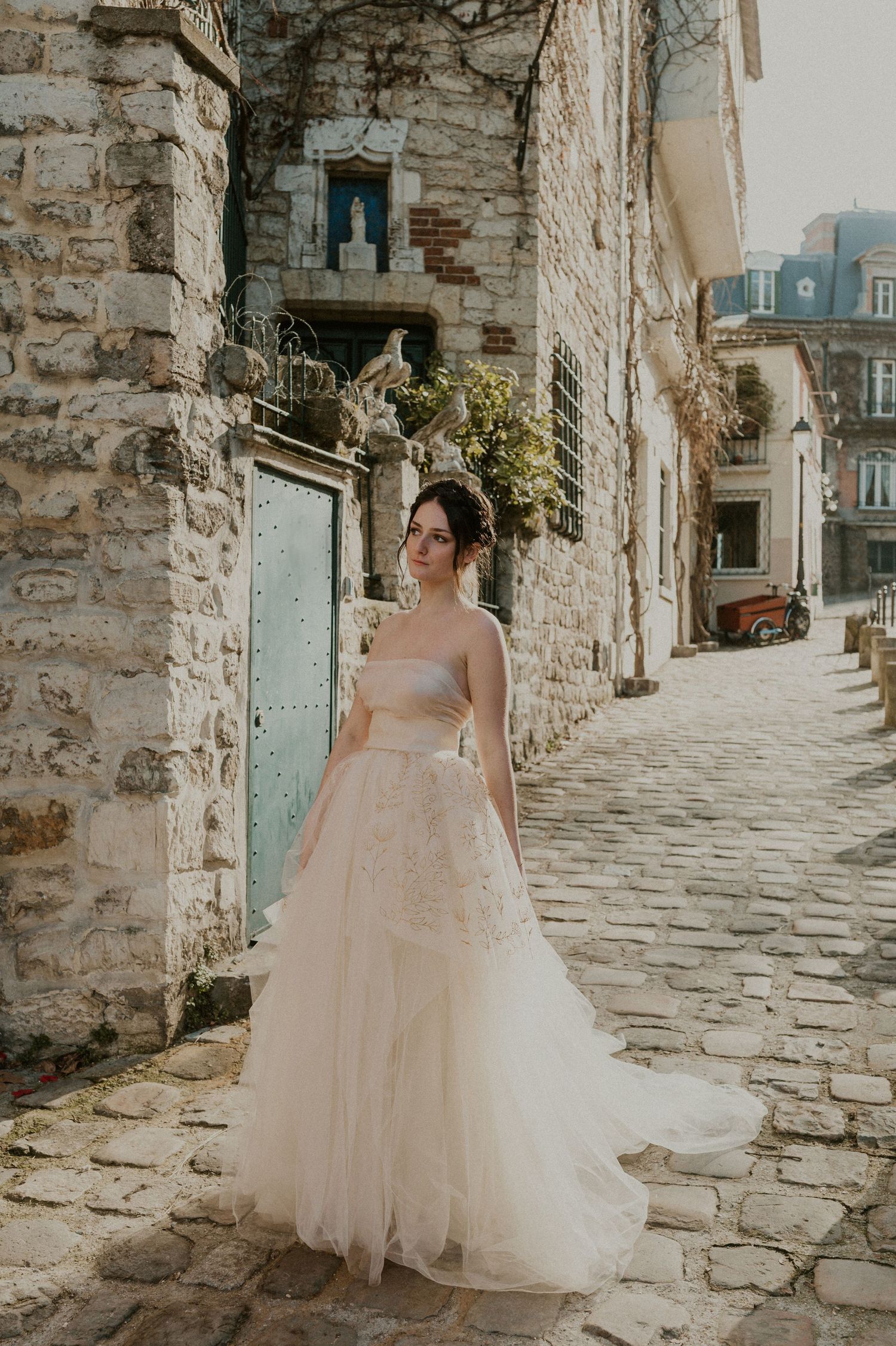 Elegant wedding dress photographed in a charming European stone alleyway.