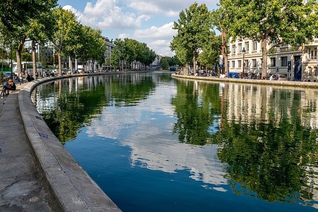 Tranquil Canal Saint-Martin in Paris with tree-lined banks and reflective water.
