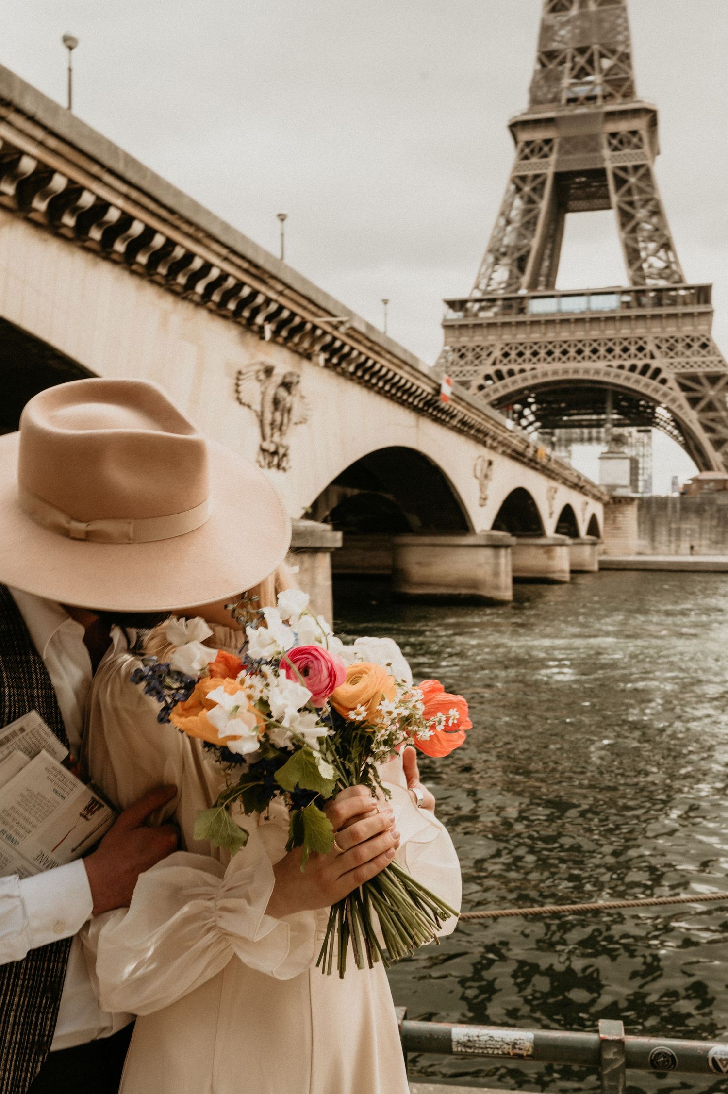 A romantic scene by the Eiffel Tower with a bouquet of flowers and vintage fashion details.