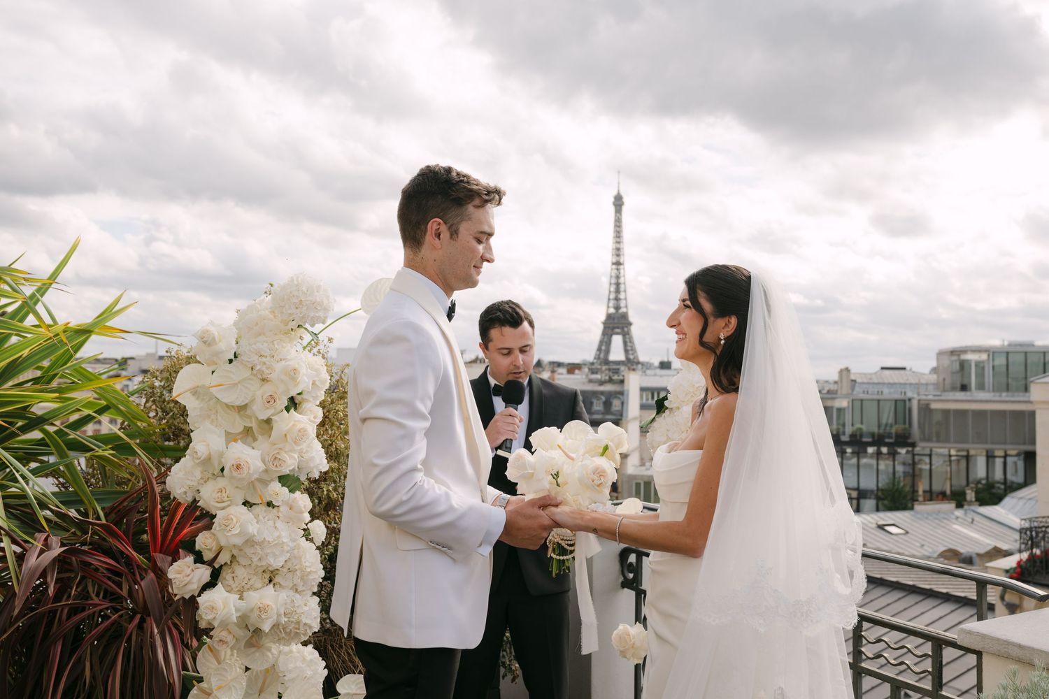Bride and groom exchange vows on rooftop with Eiffel Tower backdrop in Paris wedding ceremony.