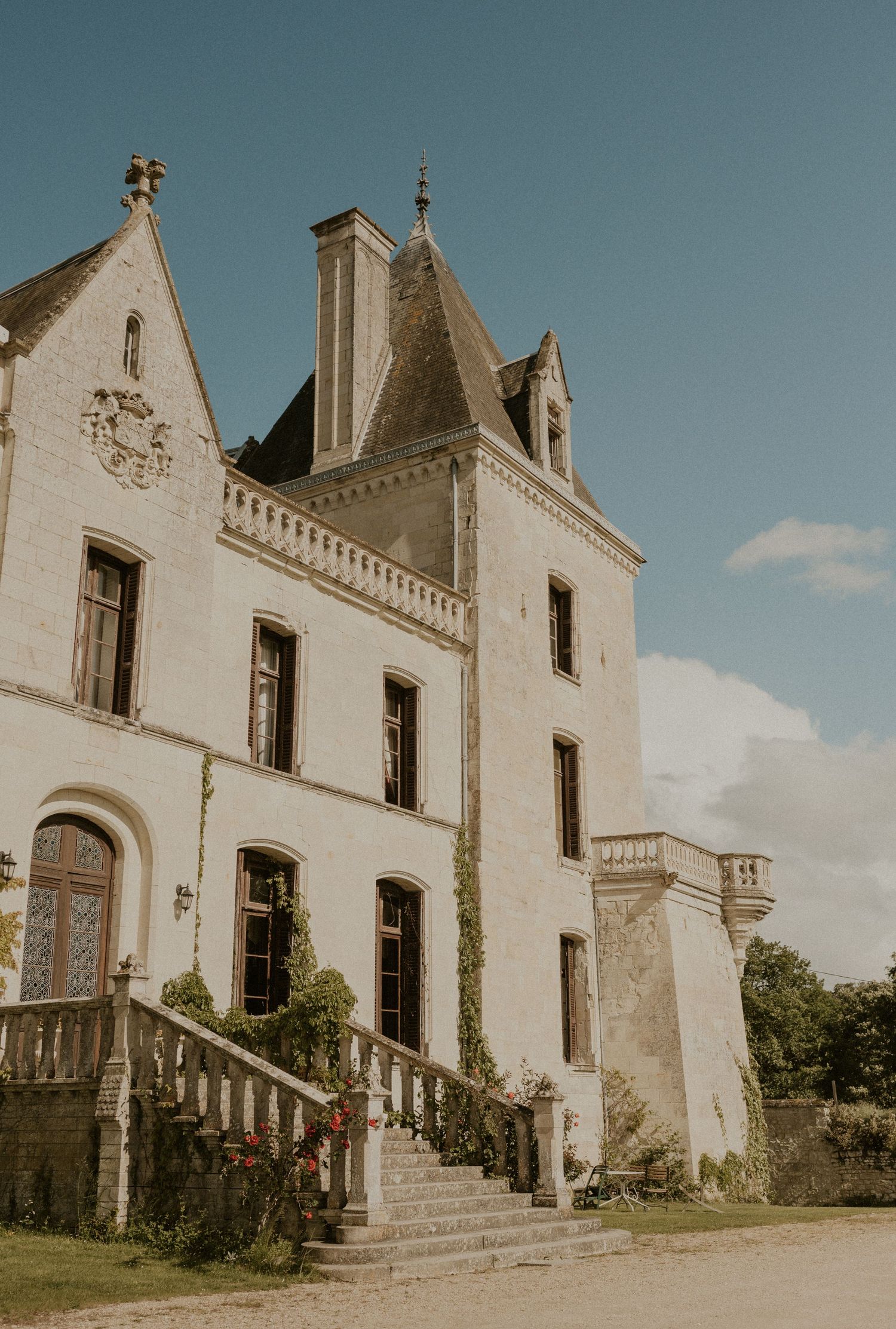 Historic French chateau exterior with dramatic architecture and stone staircase.