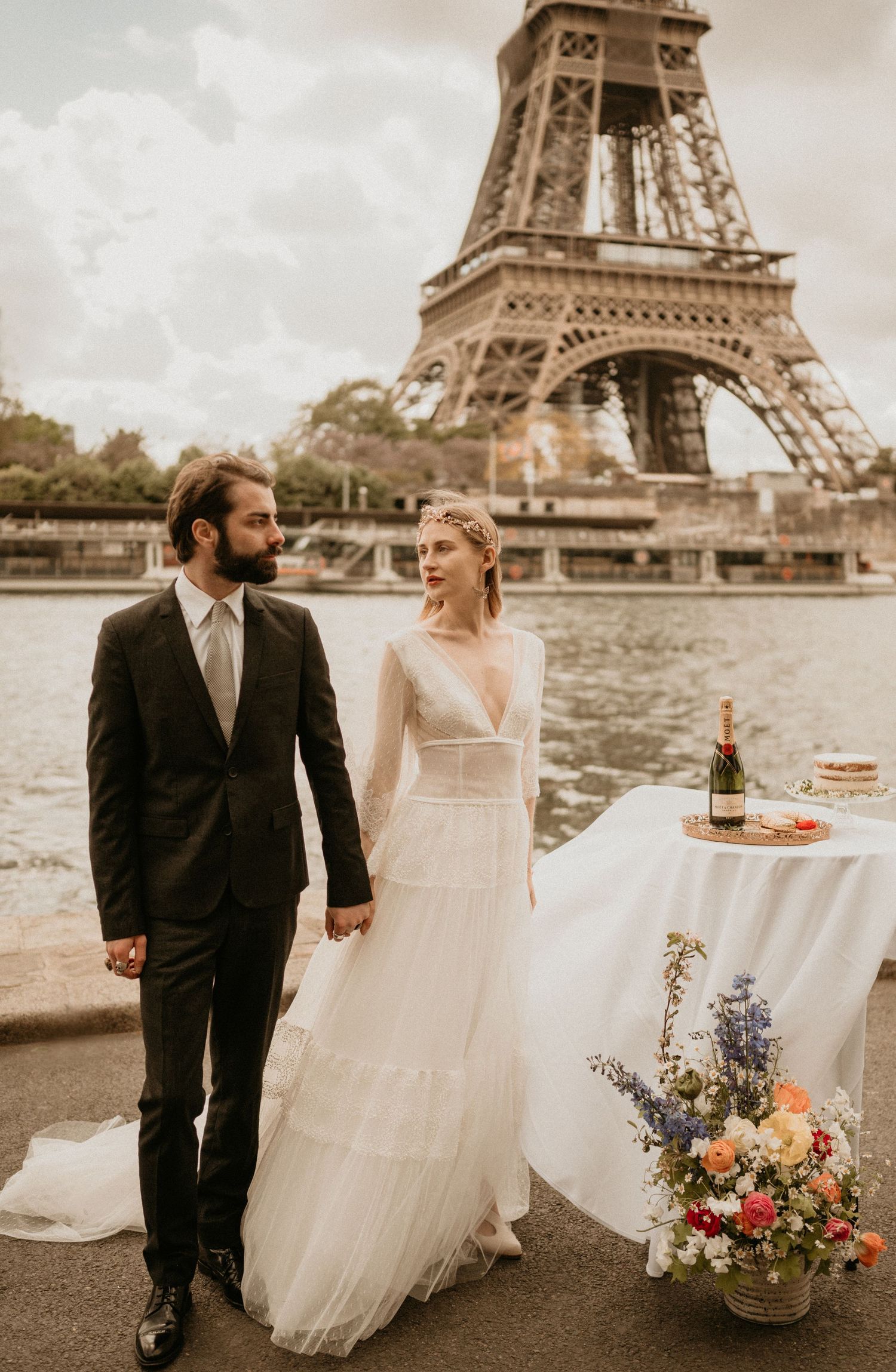 Romantic wedding photo shoot by the Eiffel Tower with elegant table setting and floral decorations.