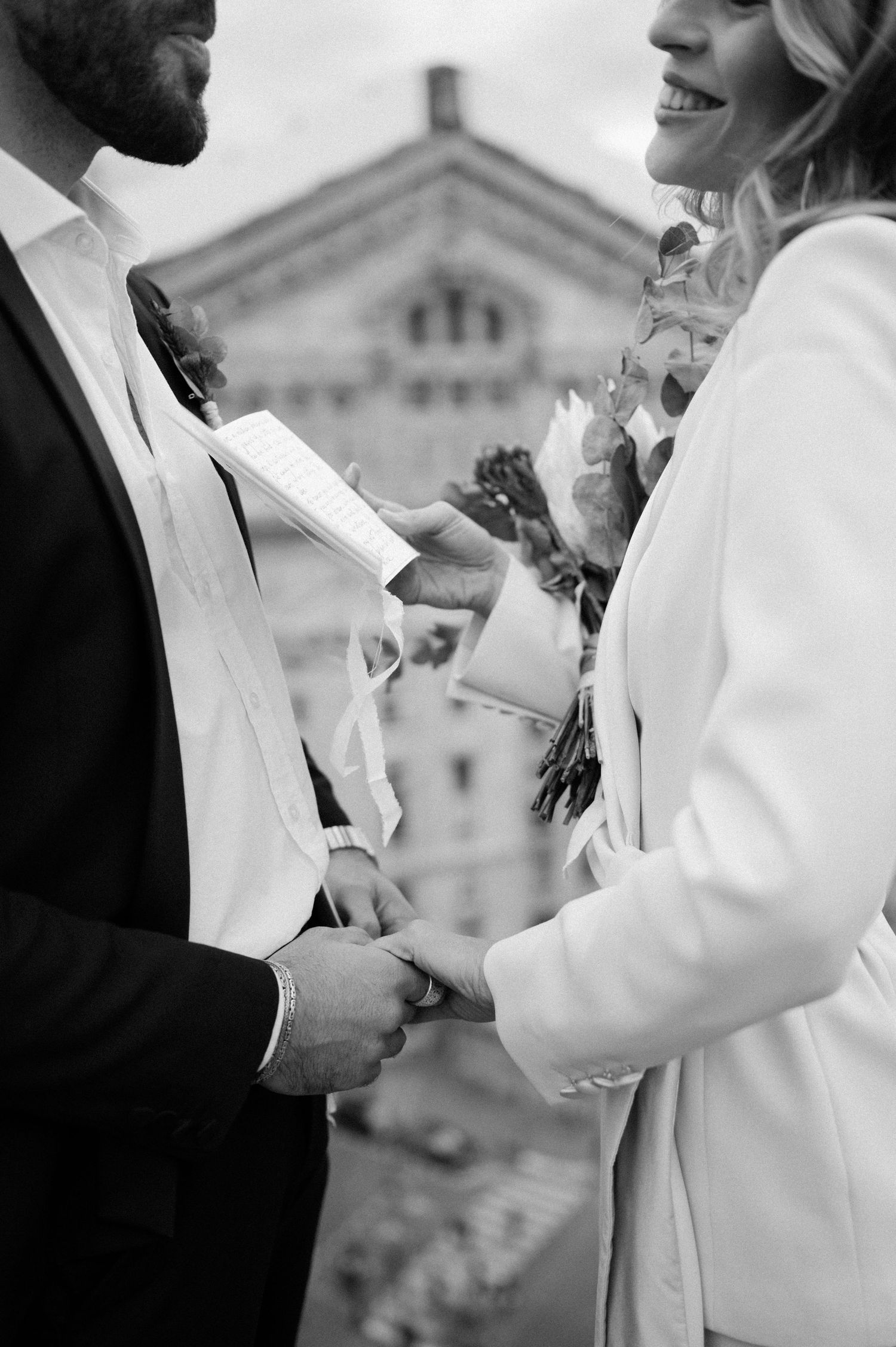 Intimate black and white wedding moment with historic Parisian architecture in background.