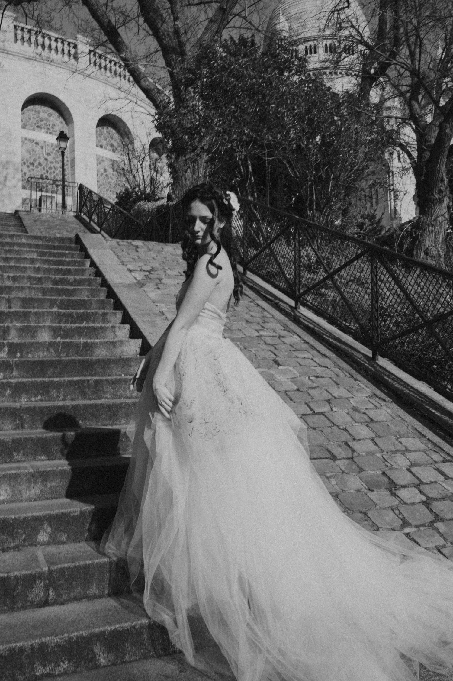 Classic bridal portrait on historic stone steps with flowing white gown and architectural backdrop.
