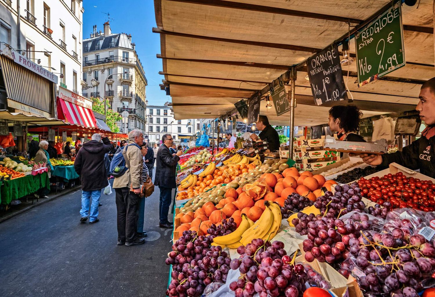 Vibrant outdoor market stall in Paris displaying colorful fresh fruits and produce.