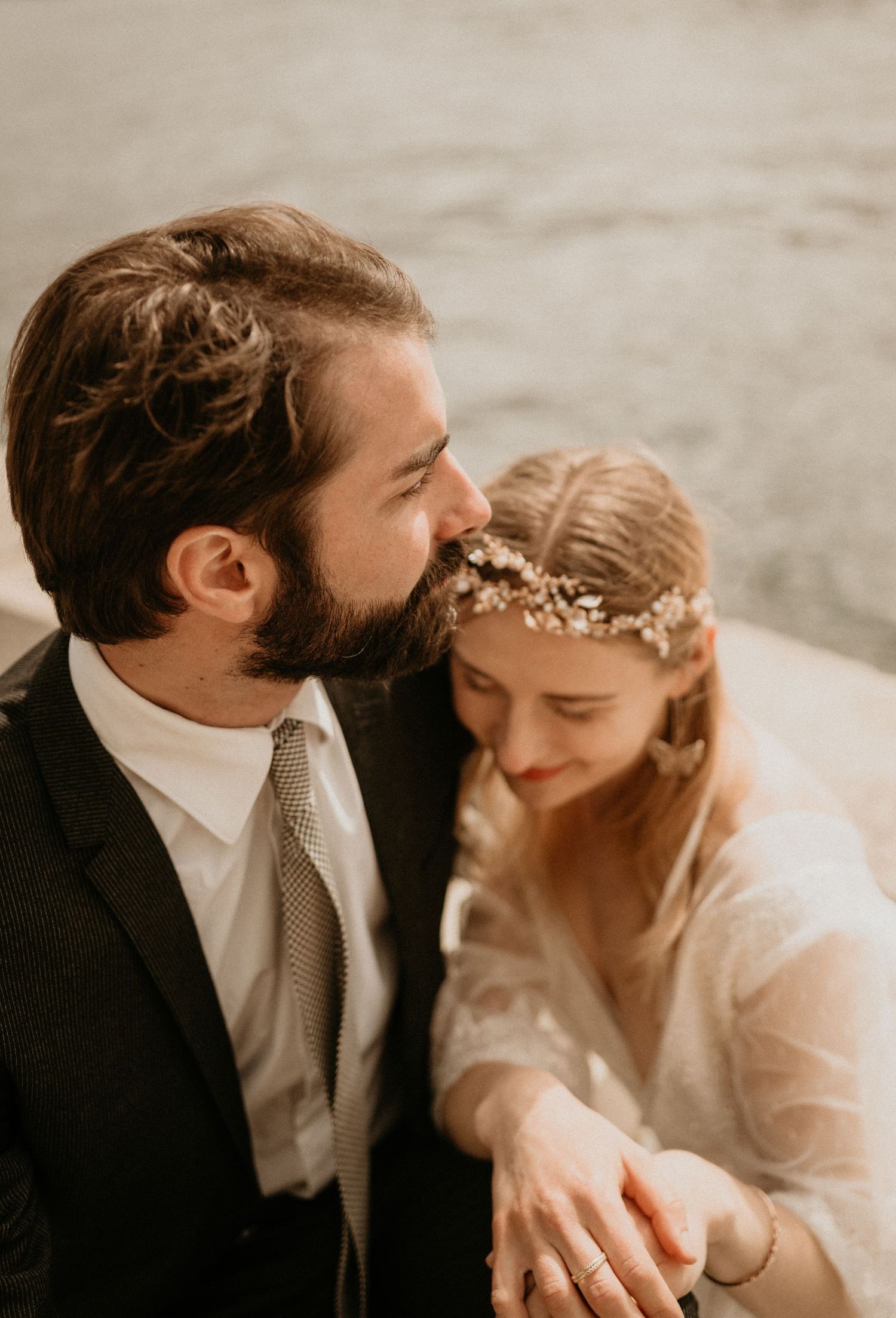 Tender wedding portrait in warm tones capturing a loving embrace by the Seine.