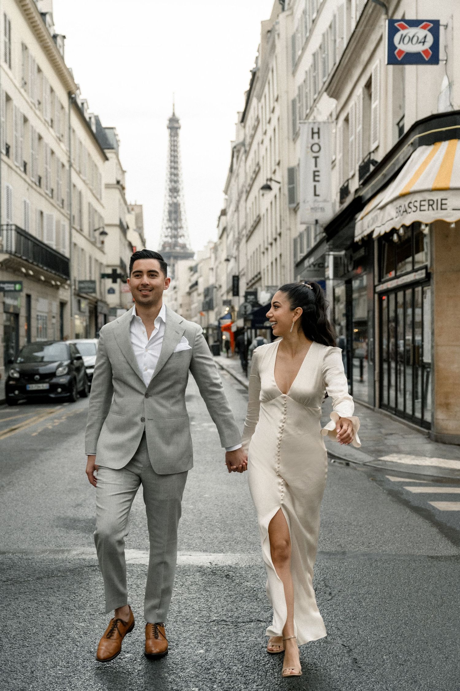 A couple walking hand in hand on a charming Paris street with the Eiffel Tower visible in the distance.
