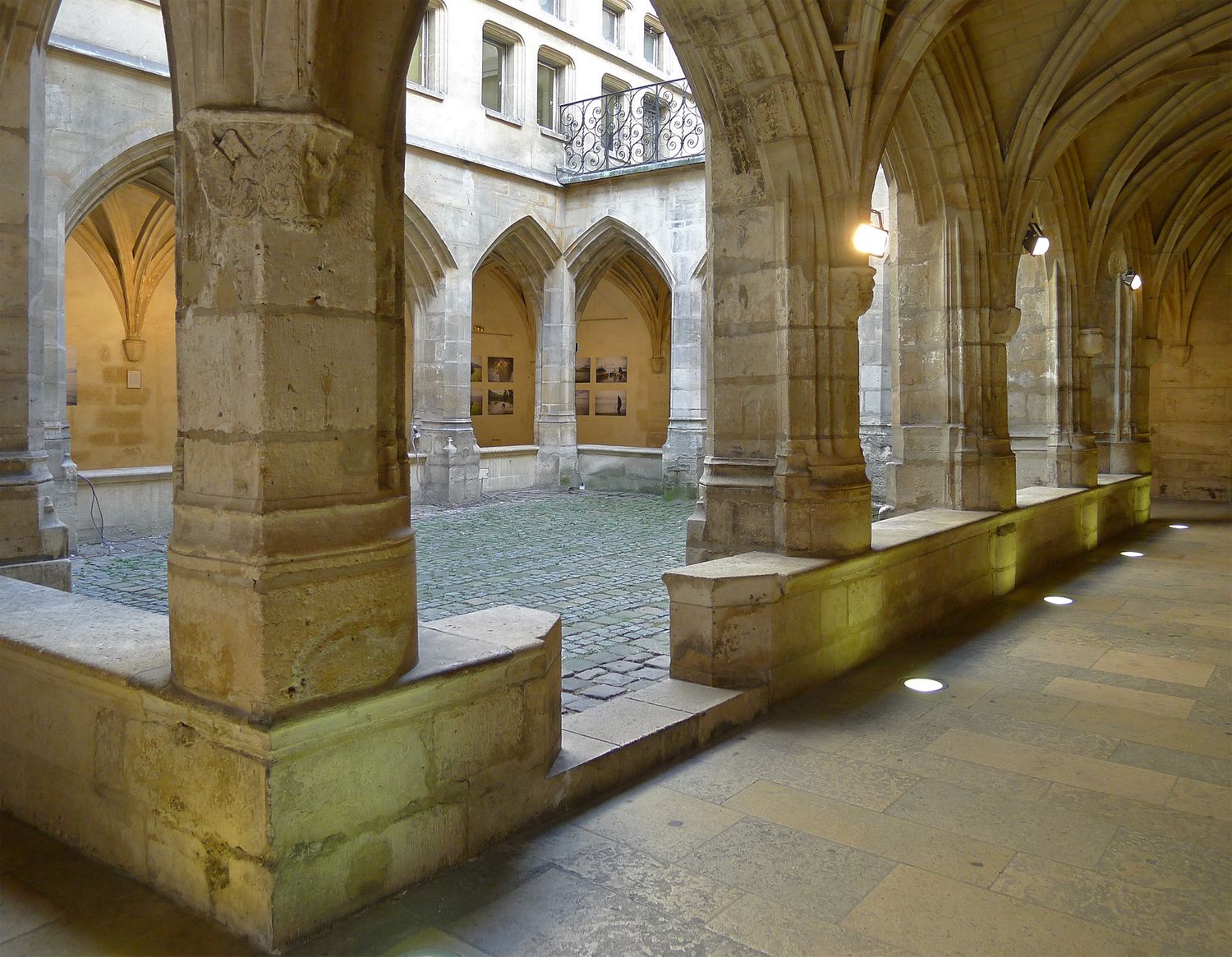 Historic stone archways and columns in a medieval courtyard passage.