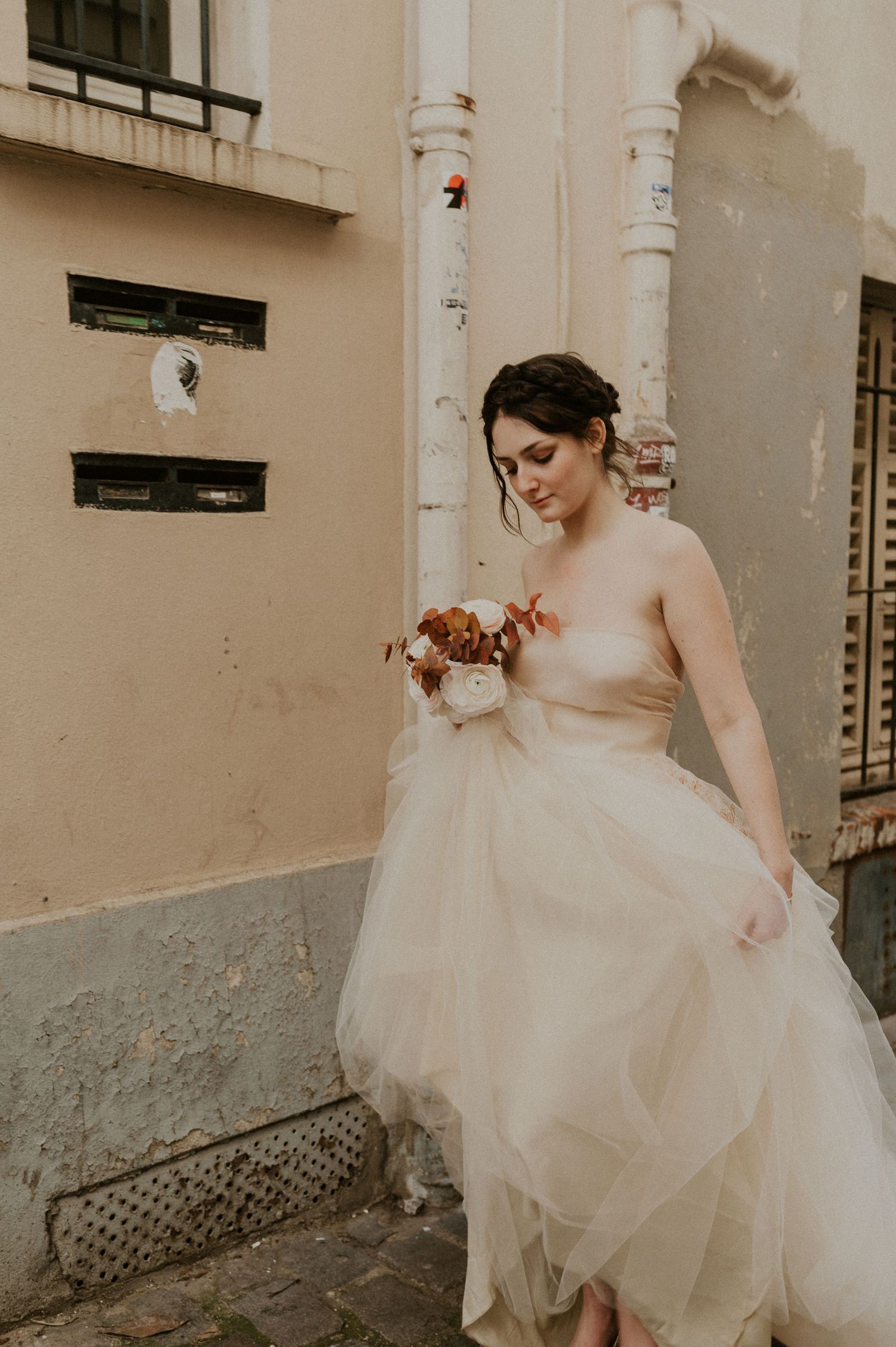 Elegant bridal portrait featuring a flowing tulle gown near vintage architectural details.