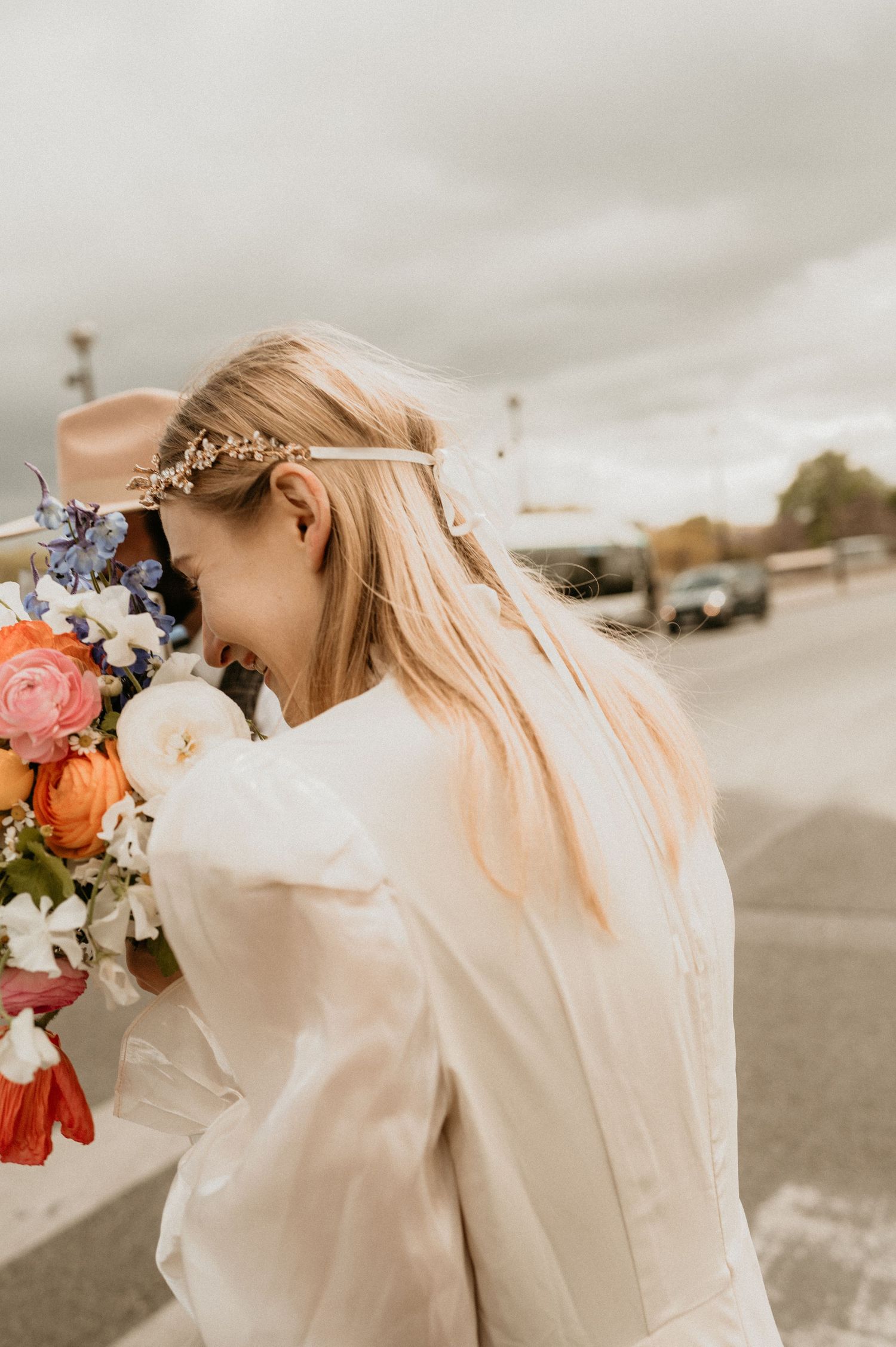 Ethereal bridal portrait with colorful bouquet and delicate floral headpiece.
