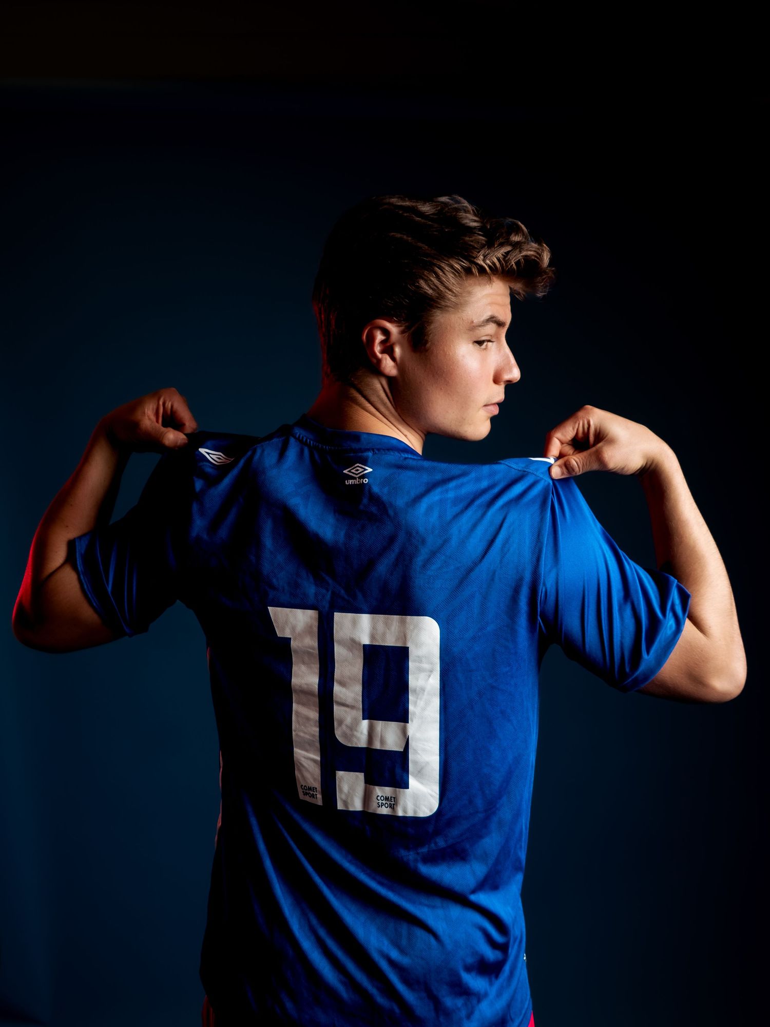 Athletic figure in blue jersey poses against dark background showing dynamic movement sequence.