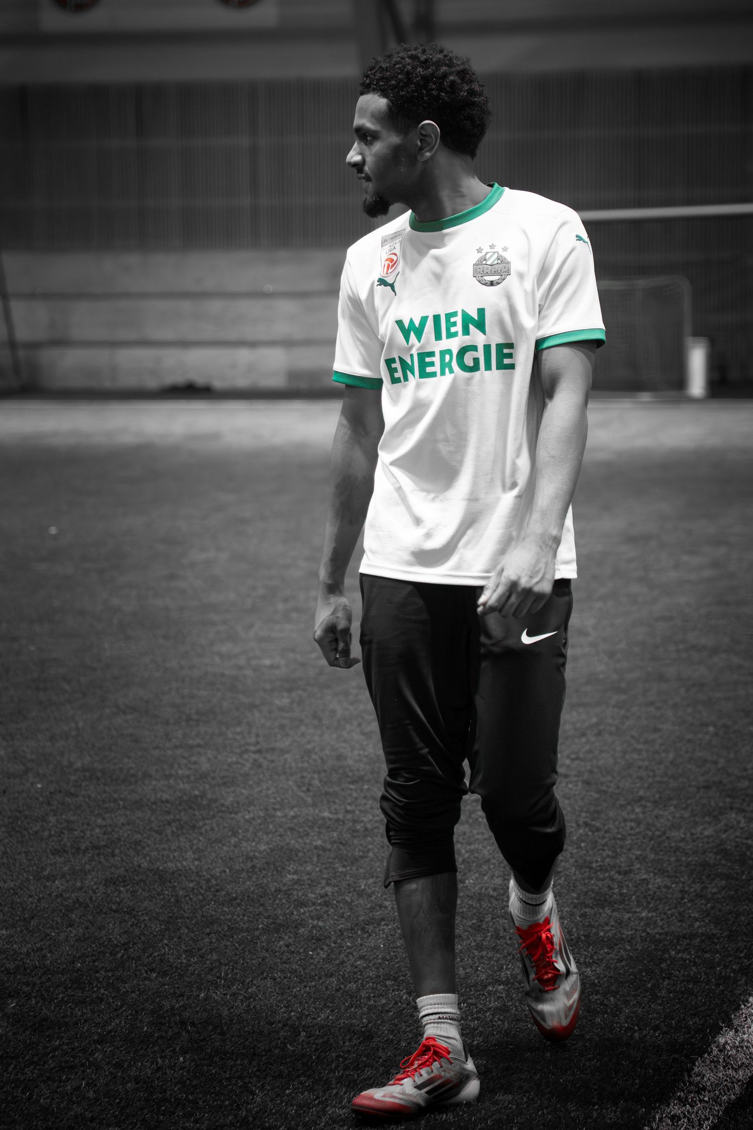 Soccer player wearing Energie Wien jersey on indoor field.