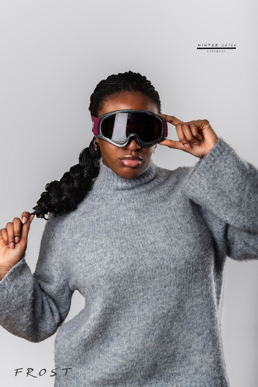 Fashion model in grey sweater and sunglasses strikes poses against white background.