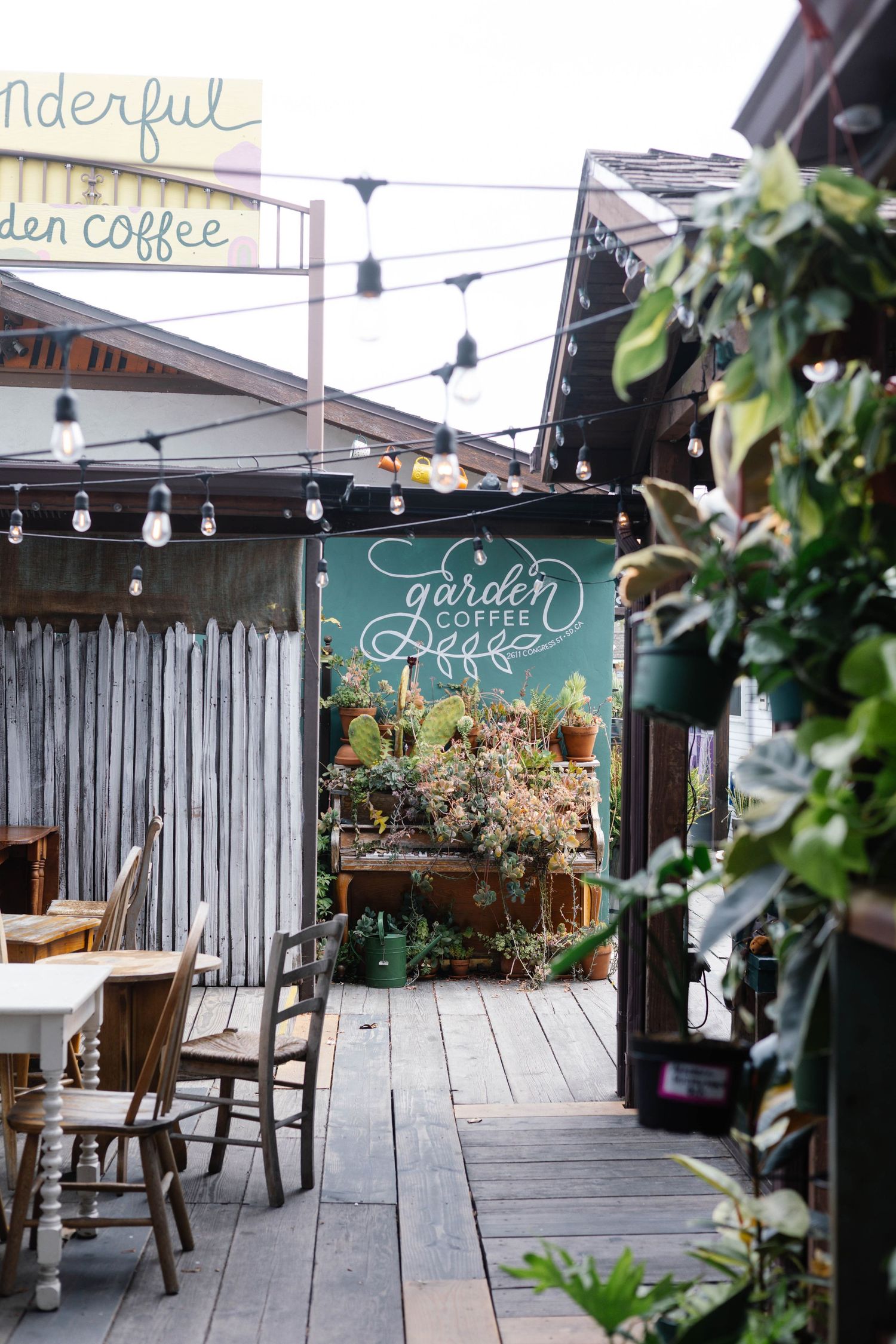 Charming outdoor garden coffee shop with string lights and rustic wooden decor.