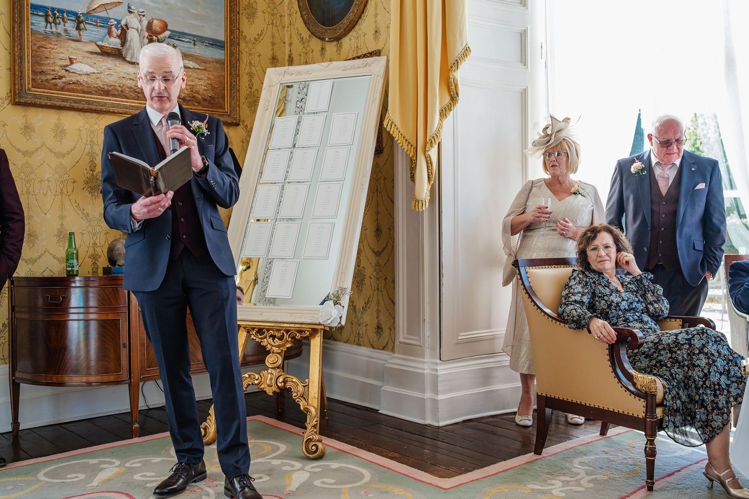 Wedding guests mingling and sharing candid moments in an elegant room with ornate decor.