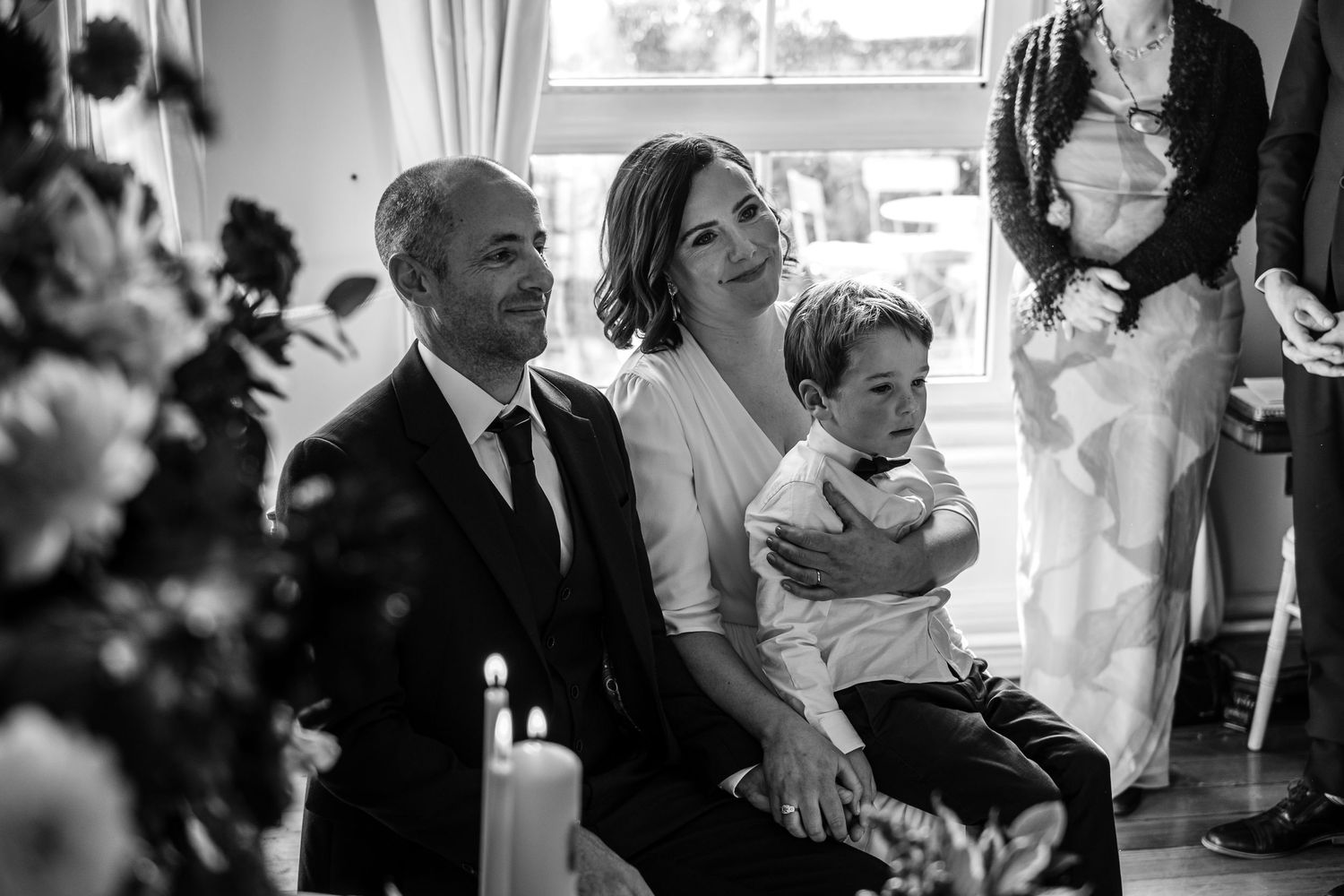 A tender family moment captured in black and white during a wedding ceremony.