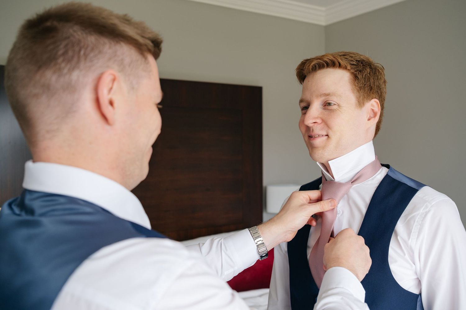 Three candid frames showing men adjusting formal neckties and getting ready.